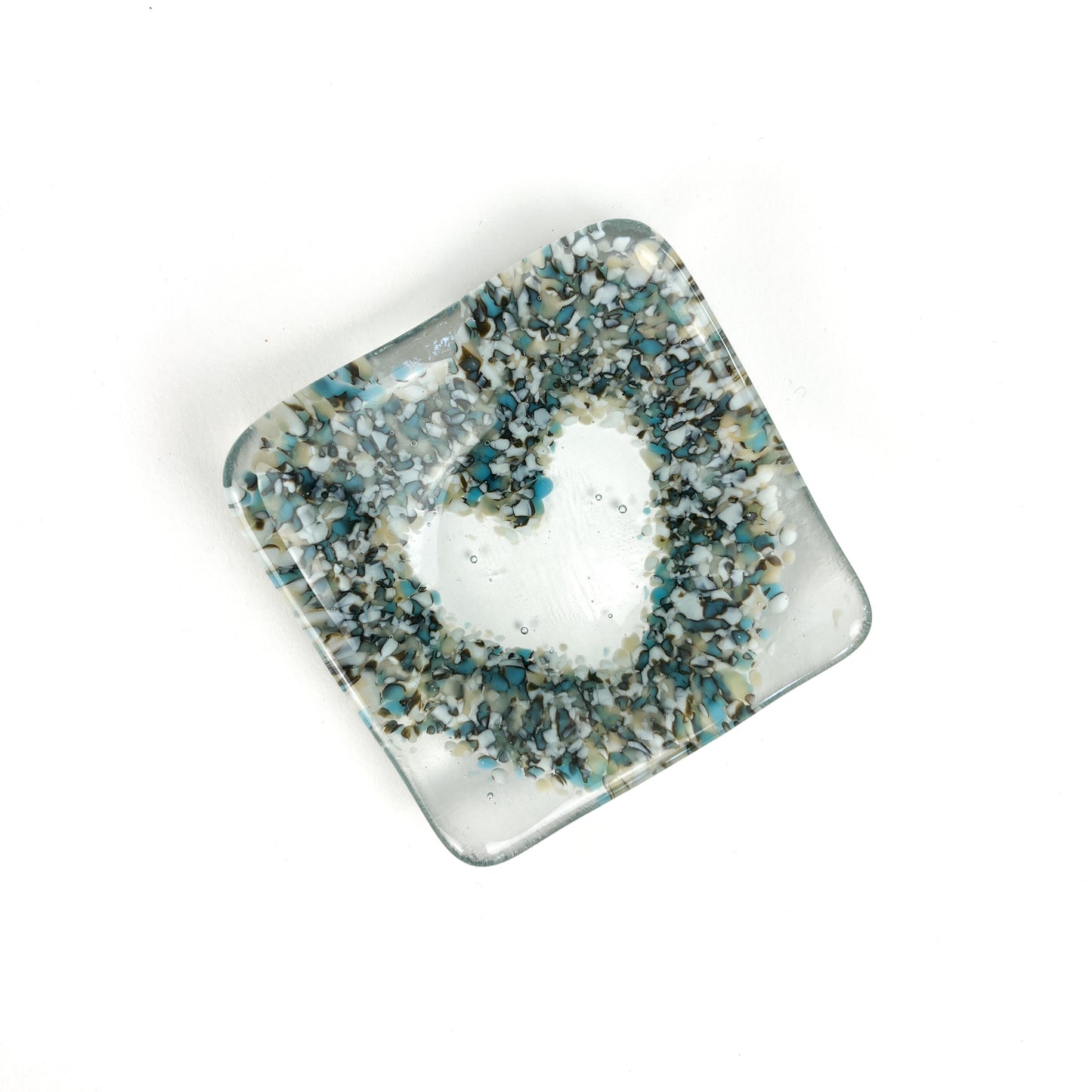 A fused glass heart bowl with a multi-colored heart pattern on a clear base.