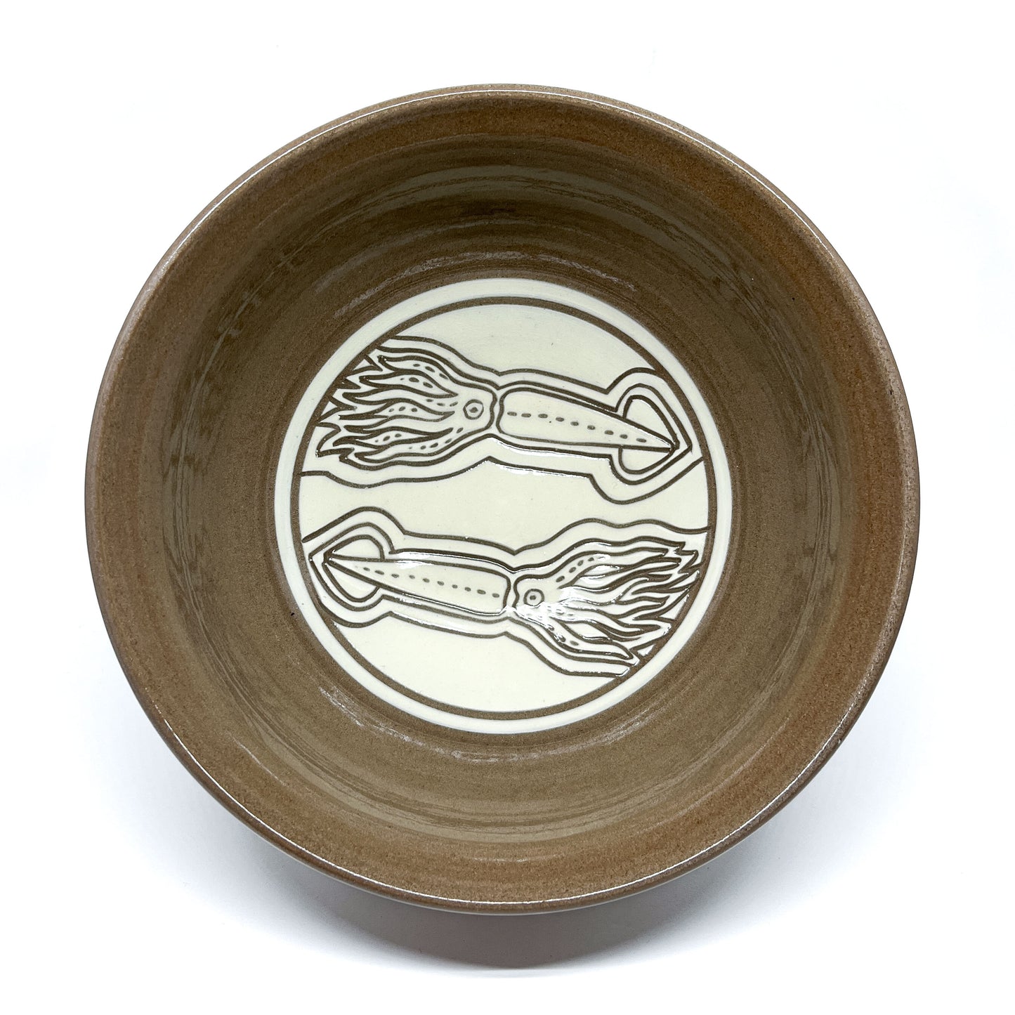 Top view of a ceramic bowl featuring two intricately carved squids facing opposite directions inside a circular frame.