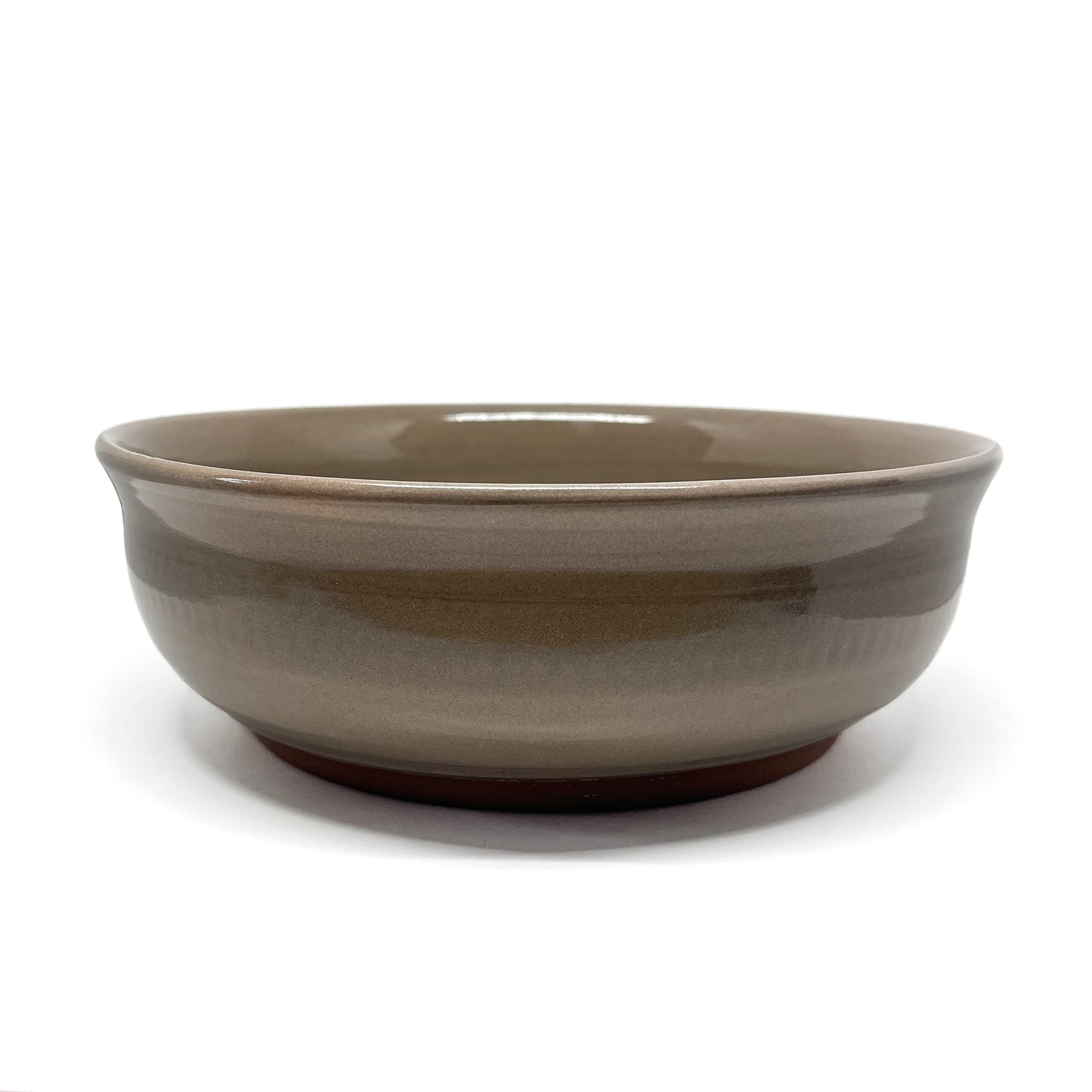 Underside of a bowl showing a carved whale in a circular medallion framed by stylized wave patterns.