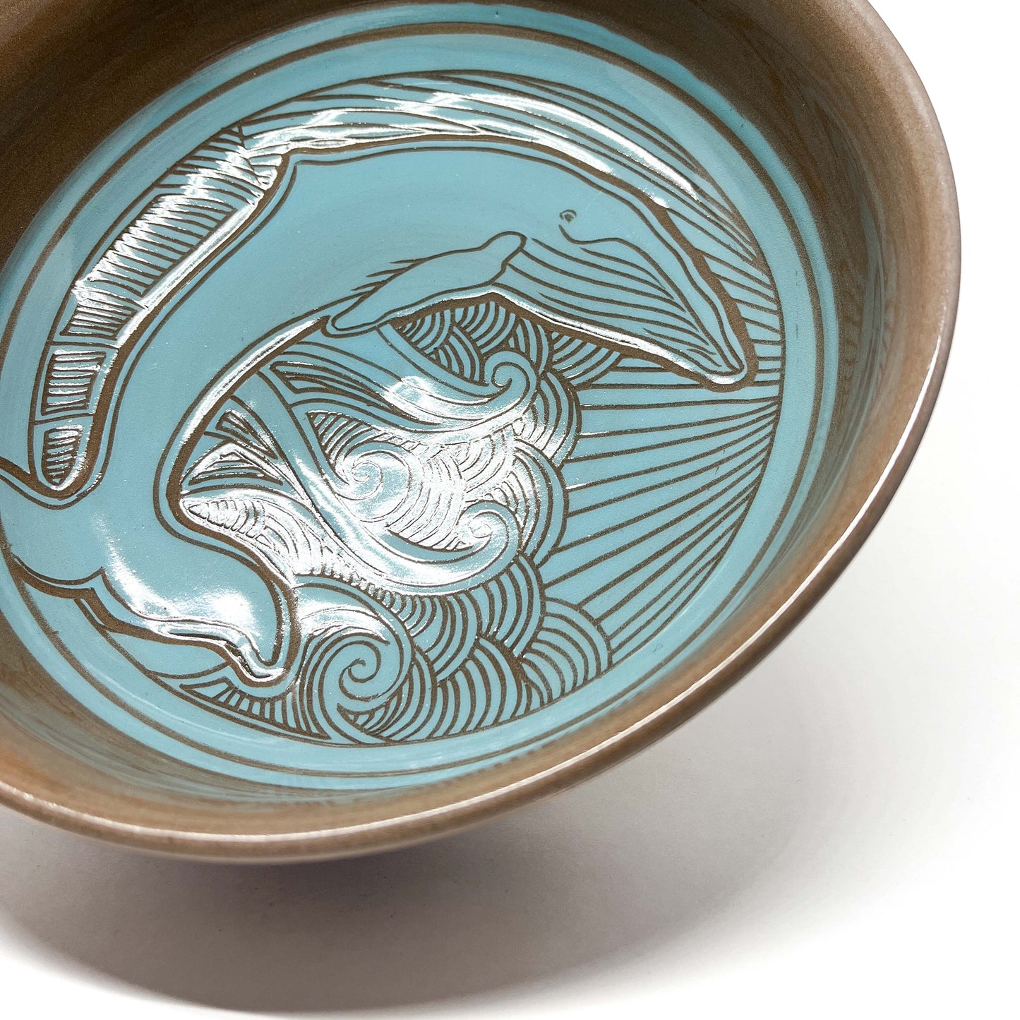 Angled view of a ceramic bowl showing an octopus design with curling tentacles and intricate background.