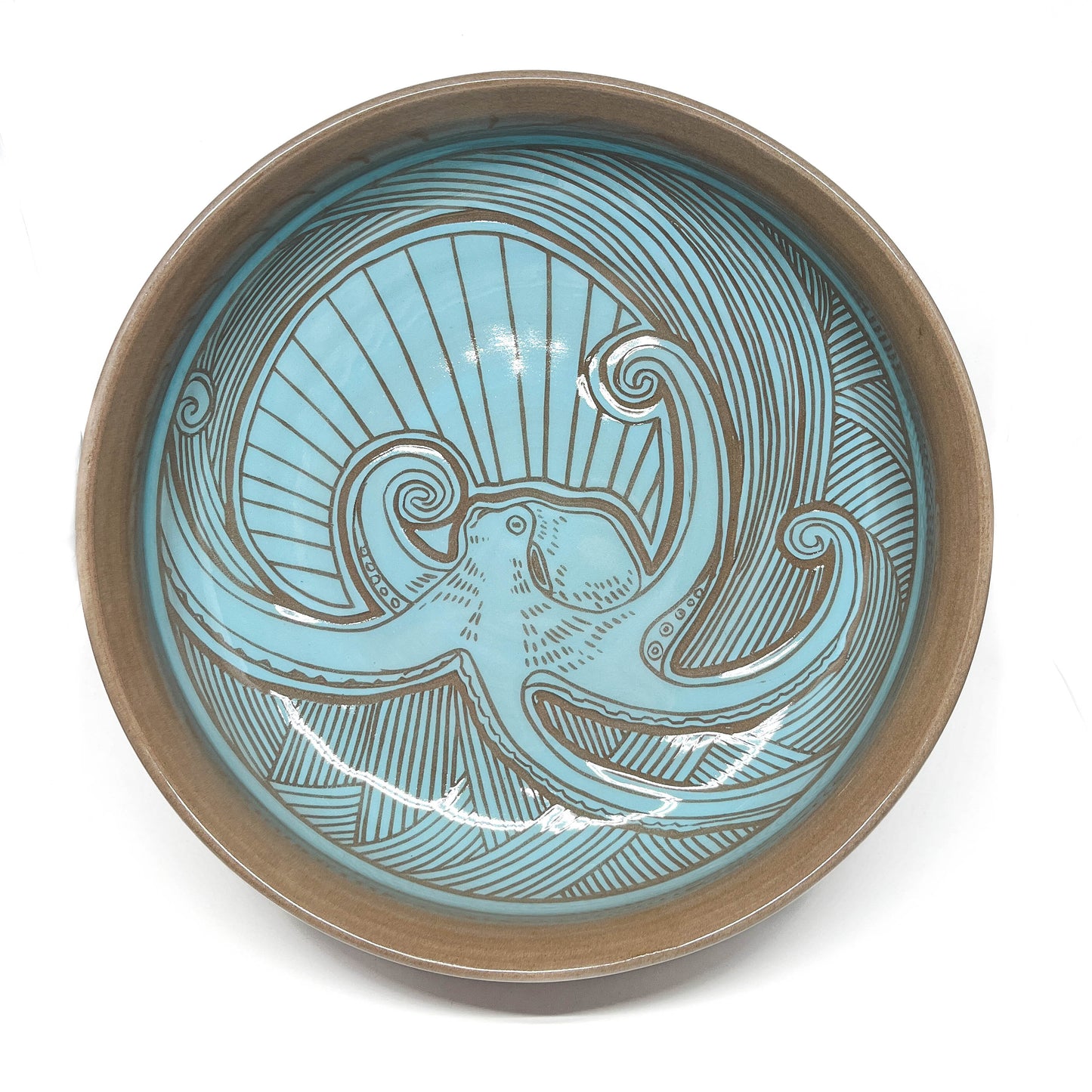 Overhead view of a ceramic bowl featuring a humpback whale, swirling sea patterns, and radiant background.