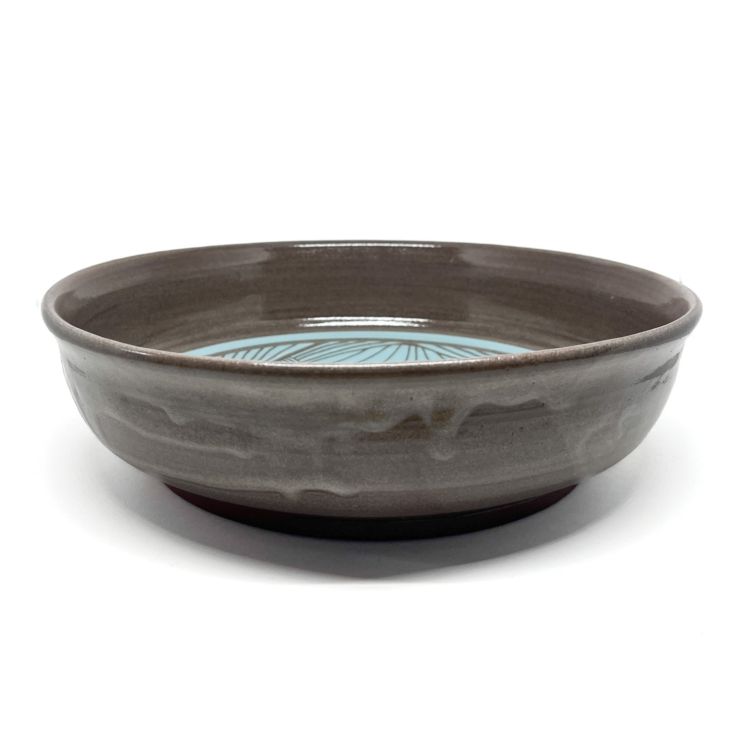 Ceramic bowl with a glazed finish and a decorative interior pattern featuring radial lines.