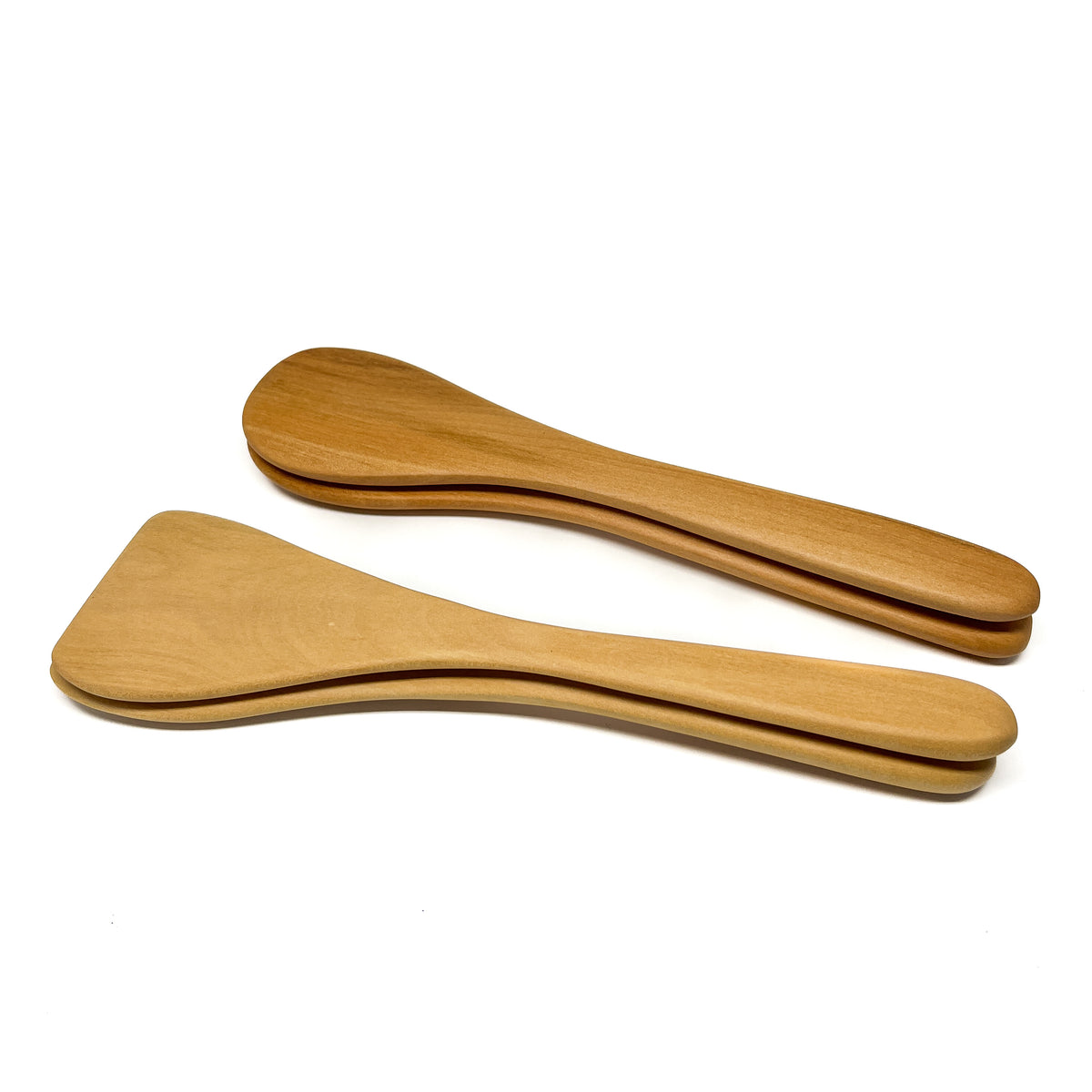 Two wooden spatulas stacked on a white surface.