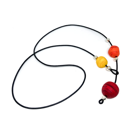 Black cord necklace with orange, yellow, and red beads.