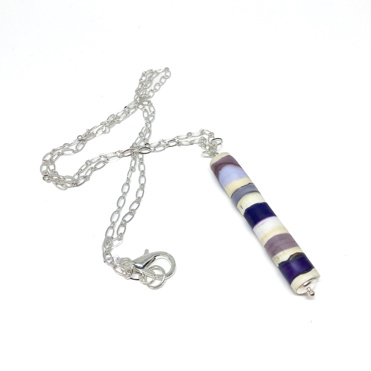 Silver chain necklace with a cylindrical pendant featuring purple, blue, and white stripes, and a small silver bead.