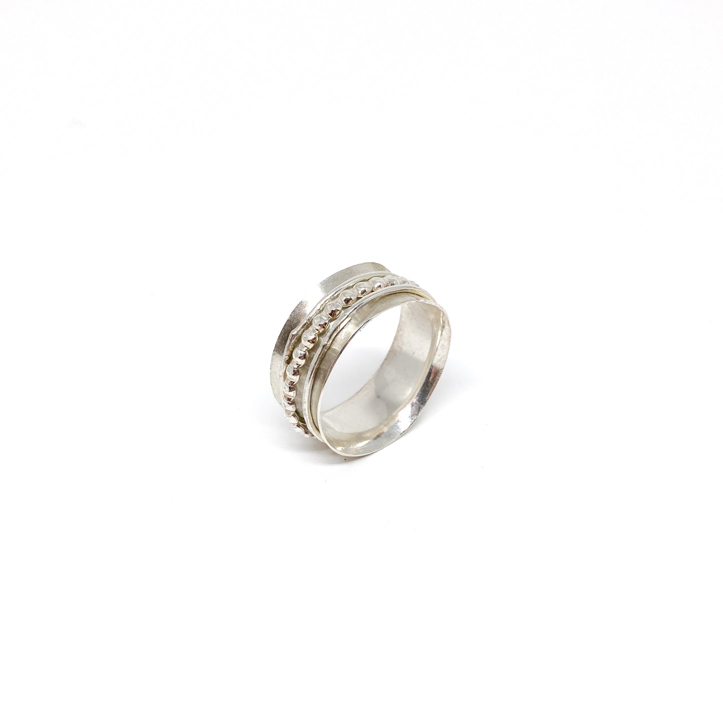 Silver spinner ring with multiple textured spinning bands, including a beaded row.