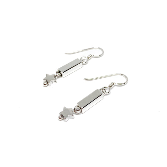 A pair of silver dangle earrings featuring a small square tube, a tiny sphere, and a star charm.