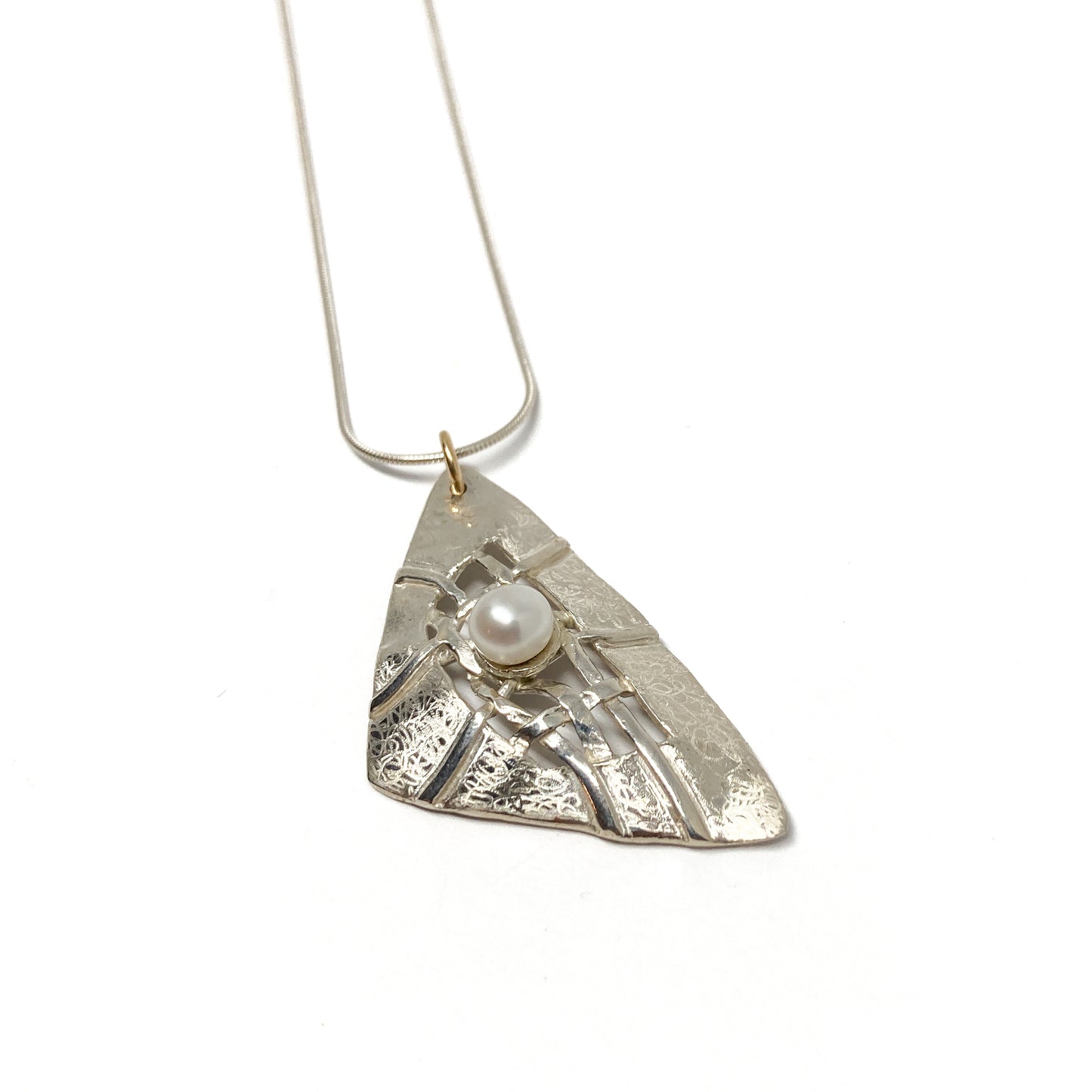 A silver pendant necklace with a triangular design, woven silver details, and a pearl accent. The pendant hangs from a delicate silver chain.