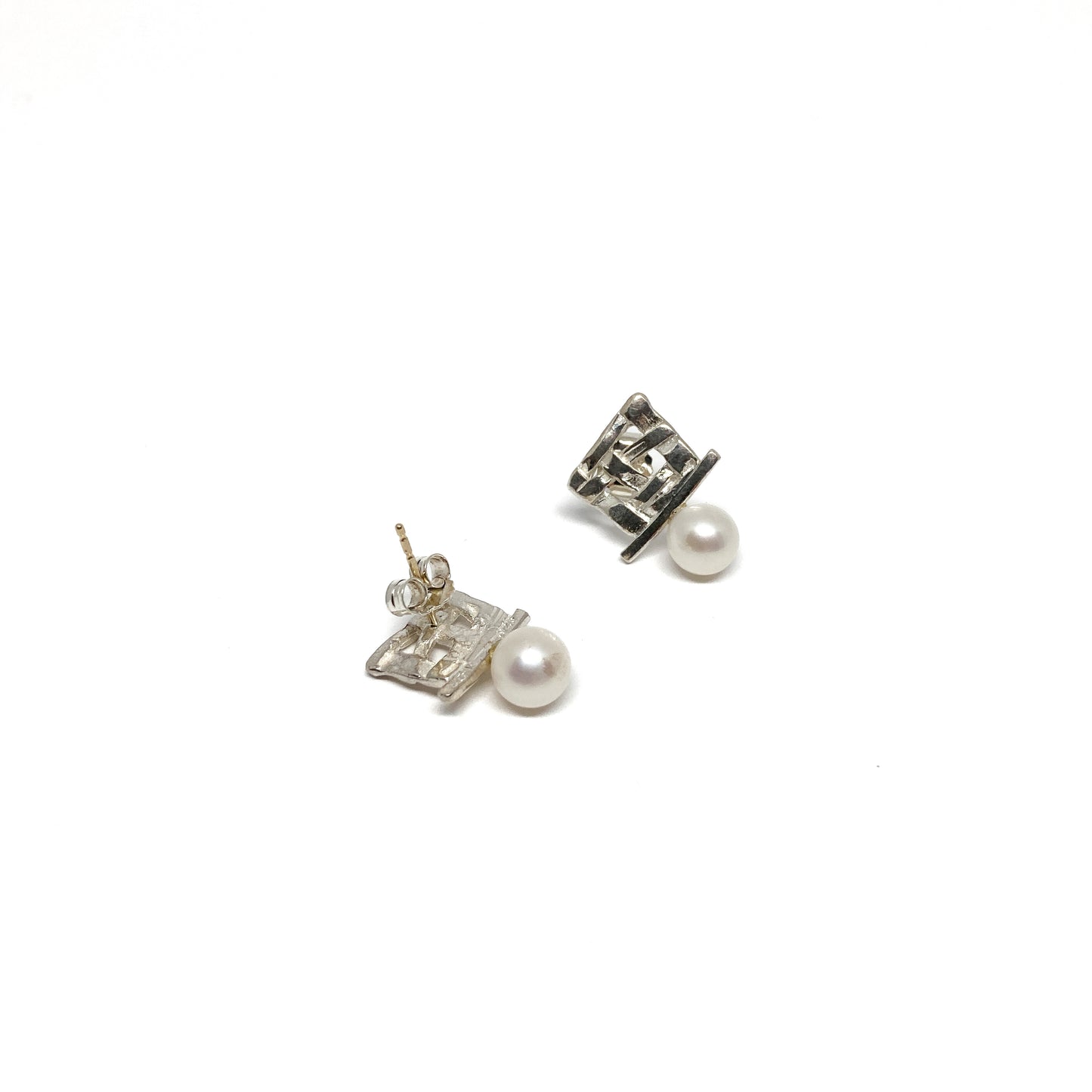 A pair of silver stud earrings with a square woven design and a single pearl accent on each. The earrings have a post back closure.