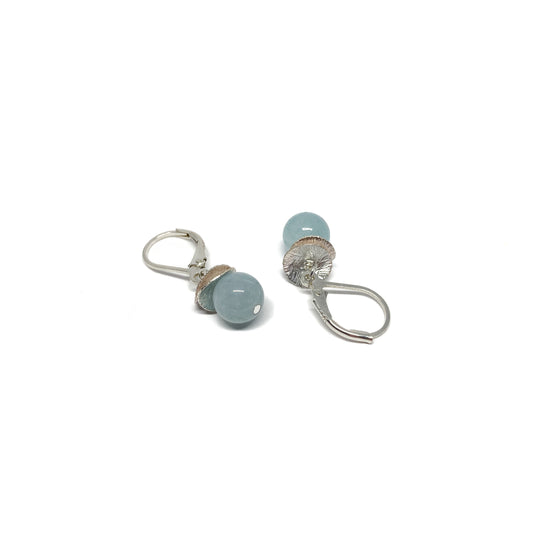 A pair of silver lever-back earrings with light blue beads and a textured, petal-like design. The earrings have a secure lever closure.