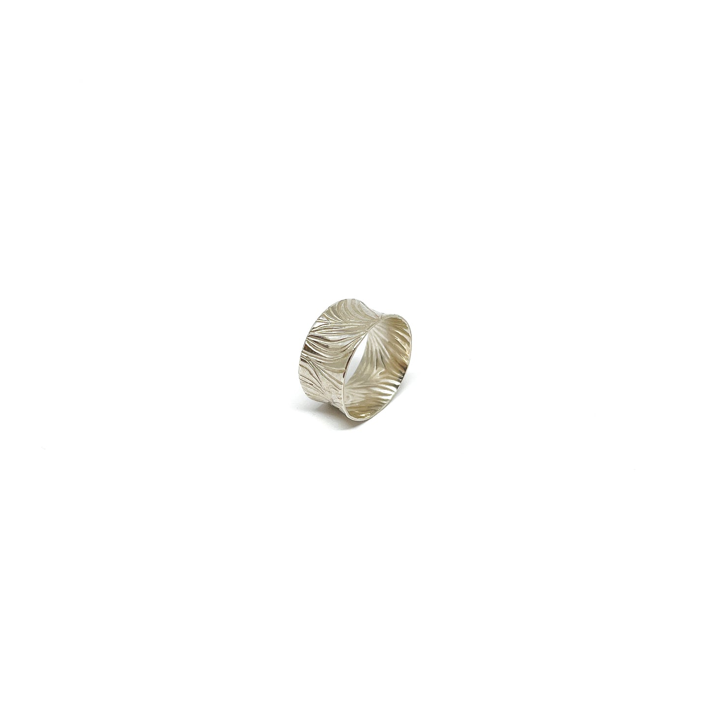 A wide sterling silver band ring with a deeply etched, flowing abstract pattern.