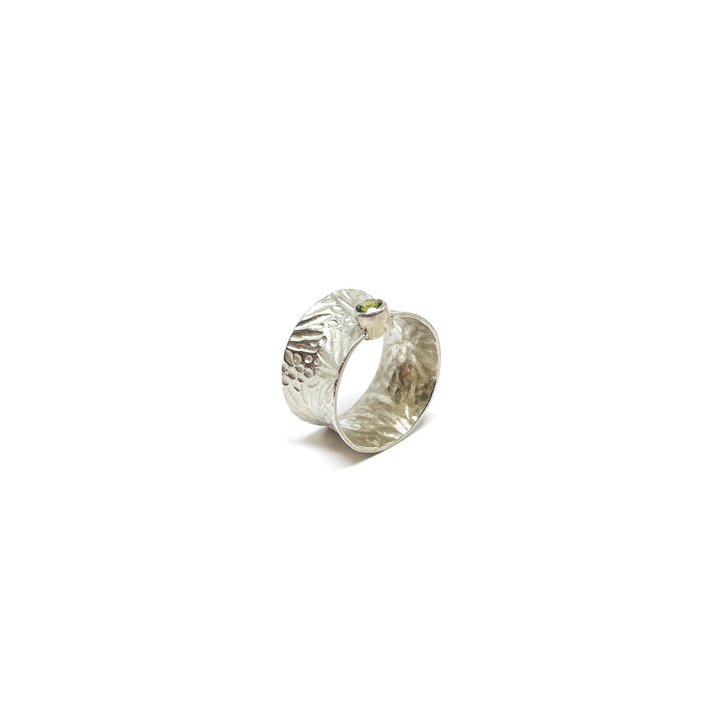Textured sterling silver spinner ring featuring a single, oval-cut peridot gemstone.