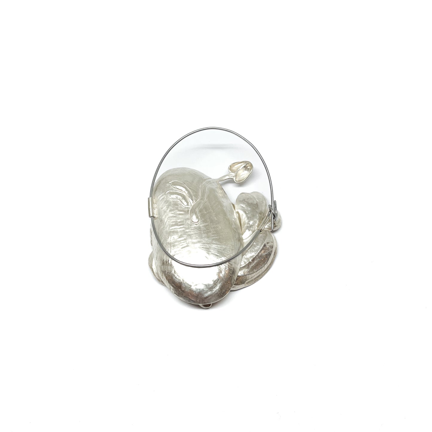 A large, textured silver brooch featuring abstract, organic shapes resembling stylized leaves or petals and a circular wire frame.