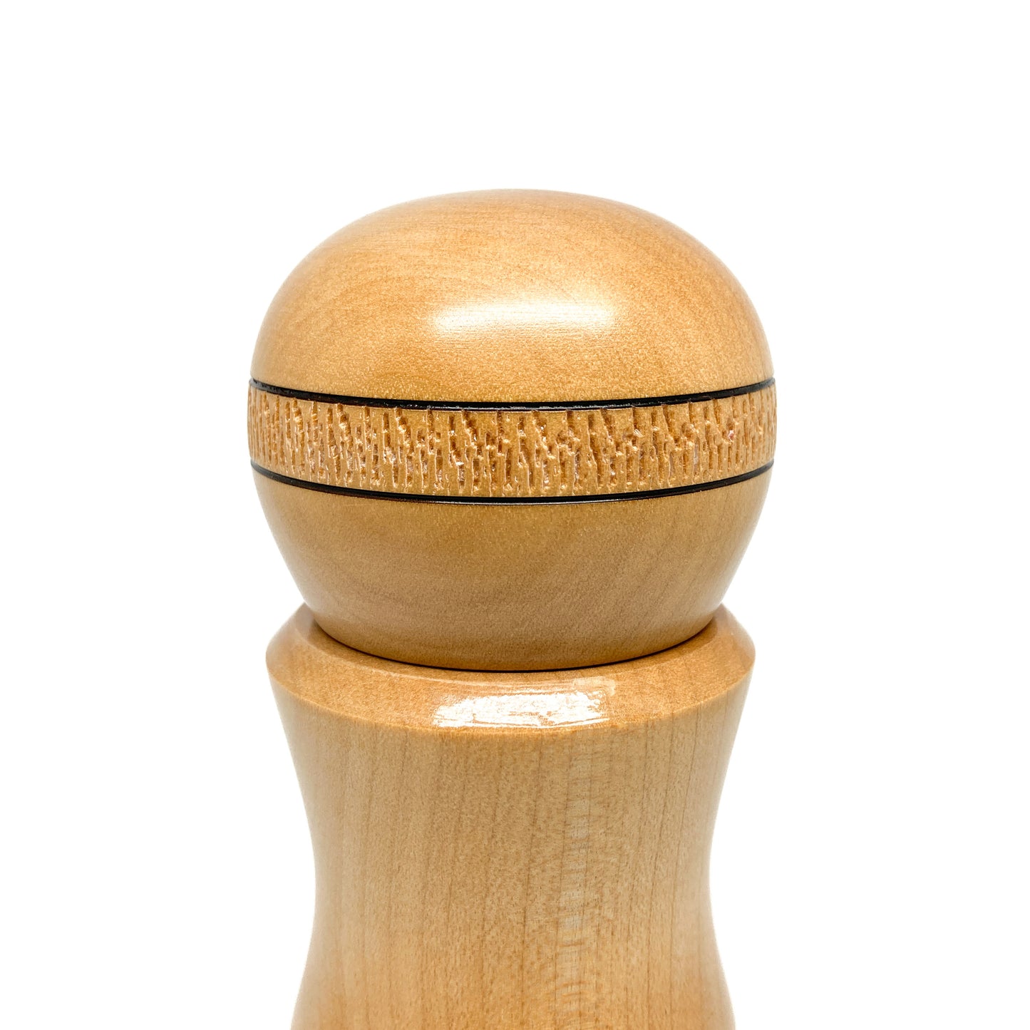 Close-up of a wooden pepper mill top, round with textured ring.