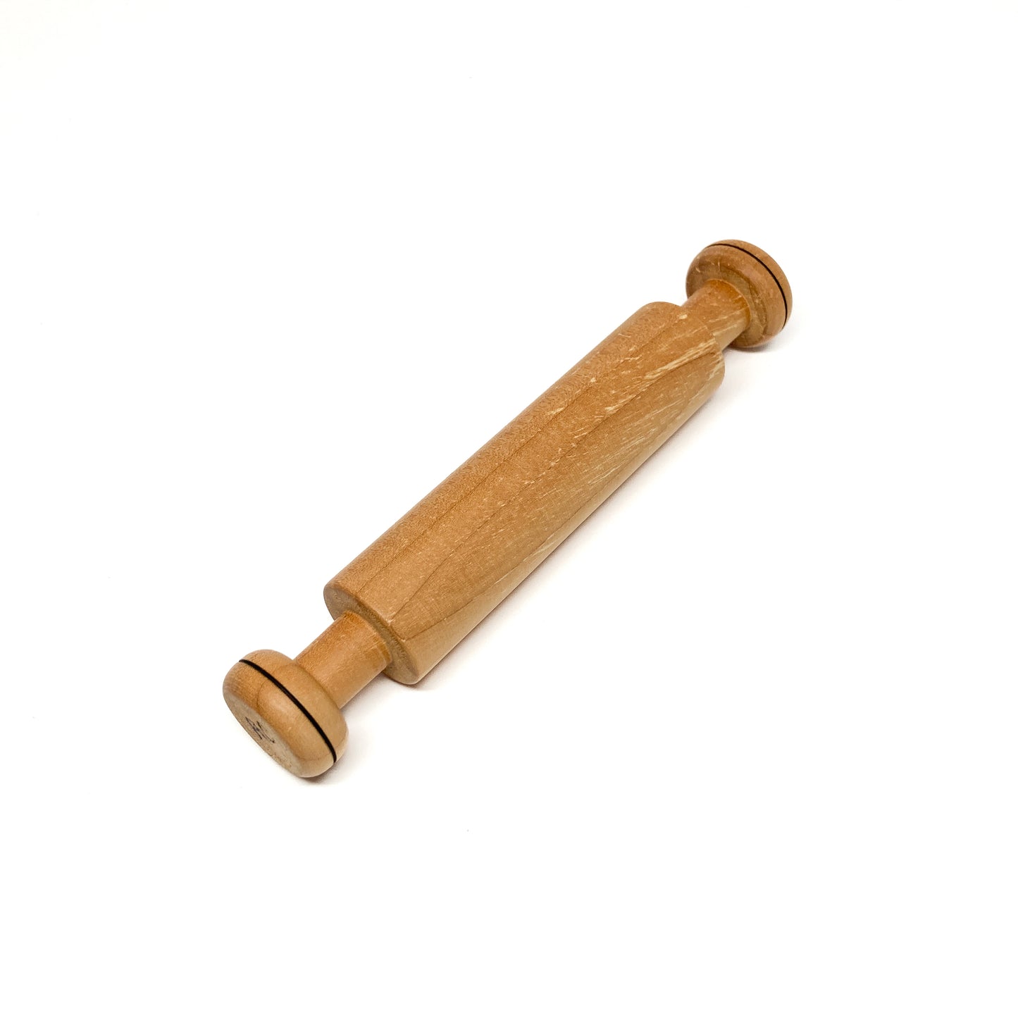 Diagonal view of a wooden rolling pin on a white background.