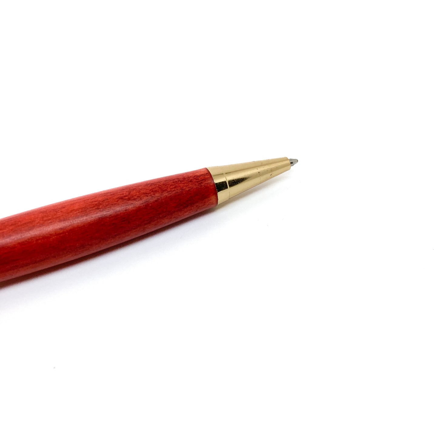 Red wood pen with gold tip, close-up view.