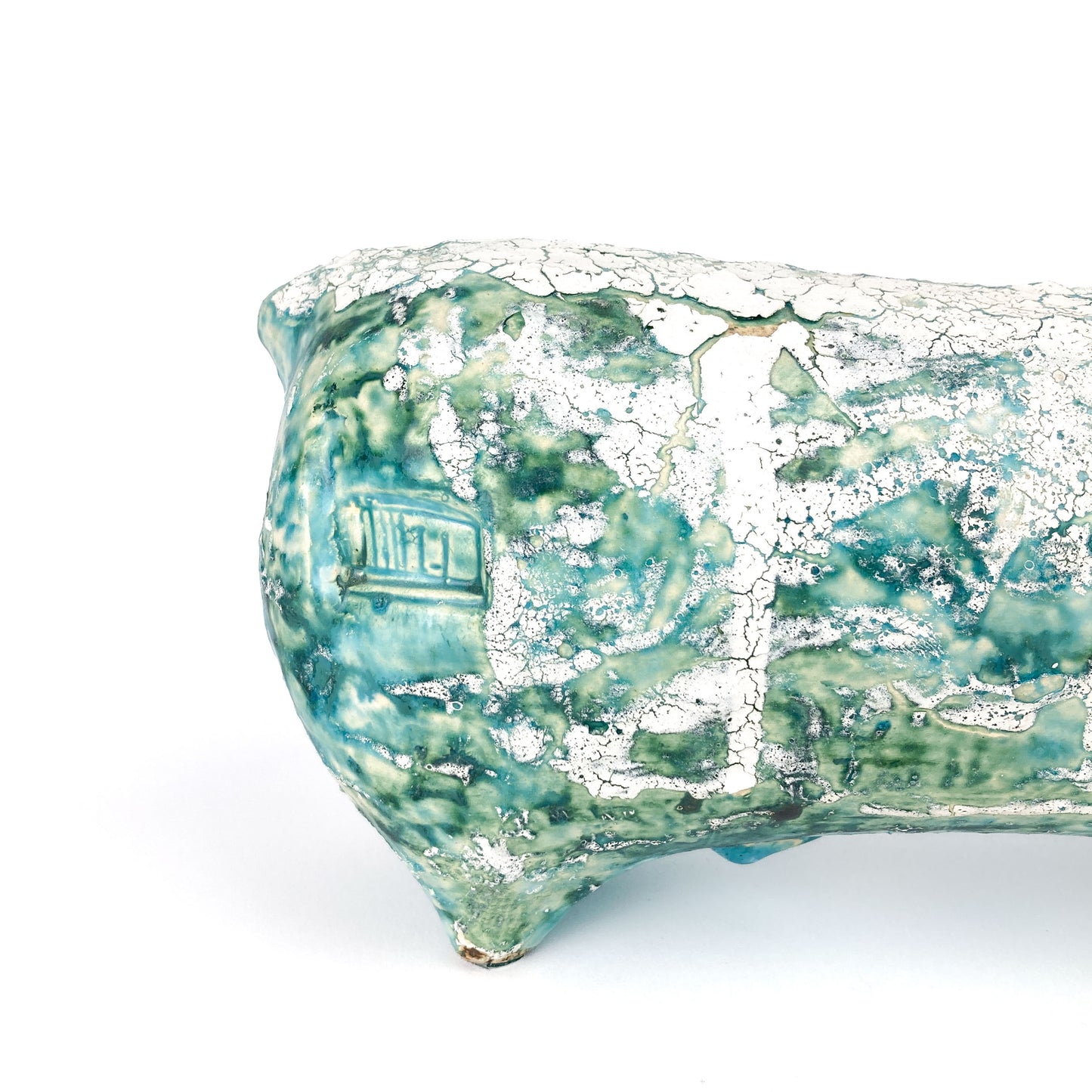 Close-up of the textured body of a teal and white ceramic bull figurine showing a mottled and crackled glaze.