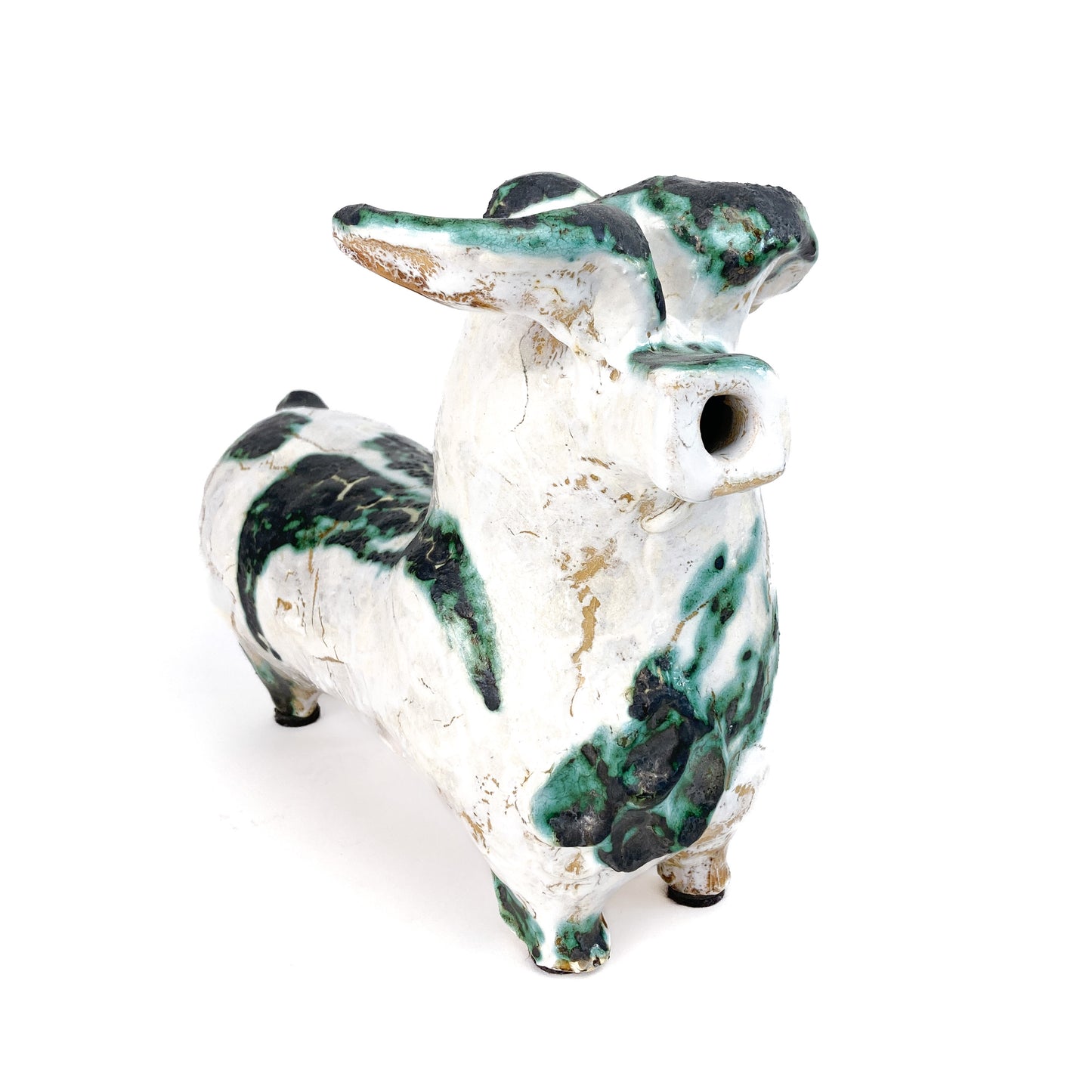A textured ceramic bull figurine with a white base and mottled teal and black markings, featuring a hollow snout.
