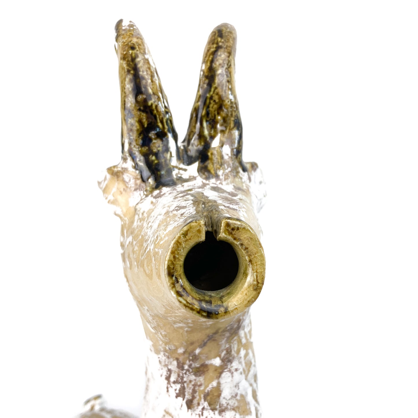 Extreme close-up of a textured ceramic Long Neck Bull's snout with a hollow opening and tall, curved horns.