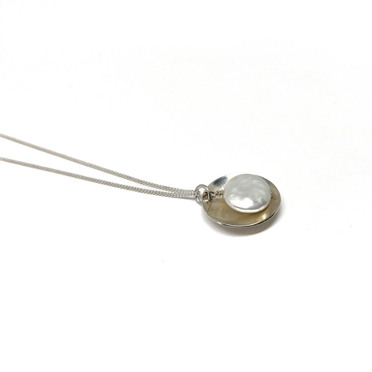 Polished Pearl Disk Pendant Necklace with smooth metal and round pearl shown from a clean, elevated angle.