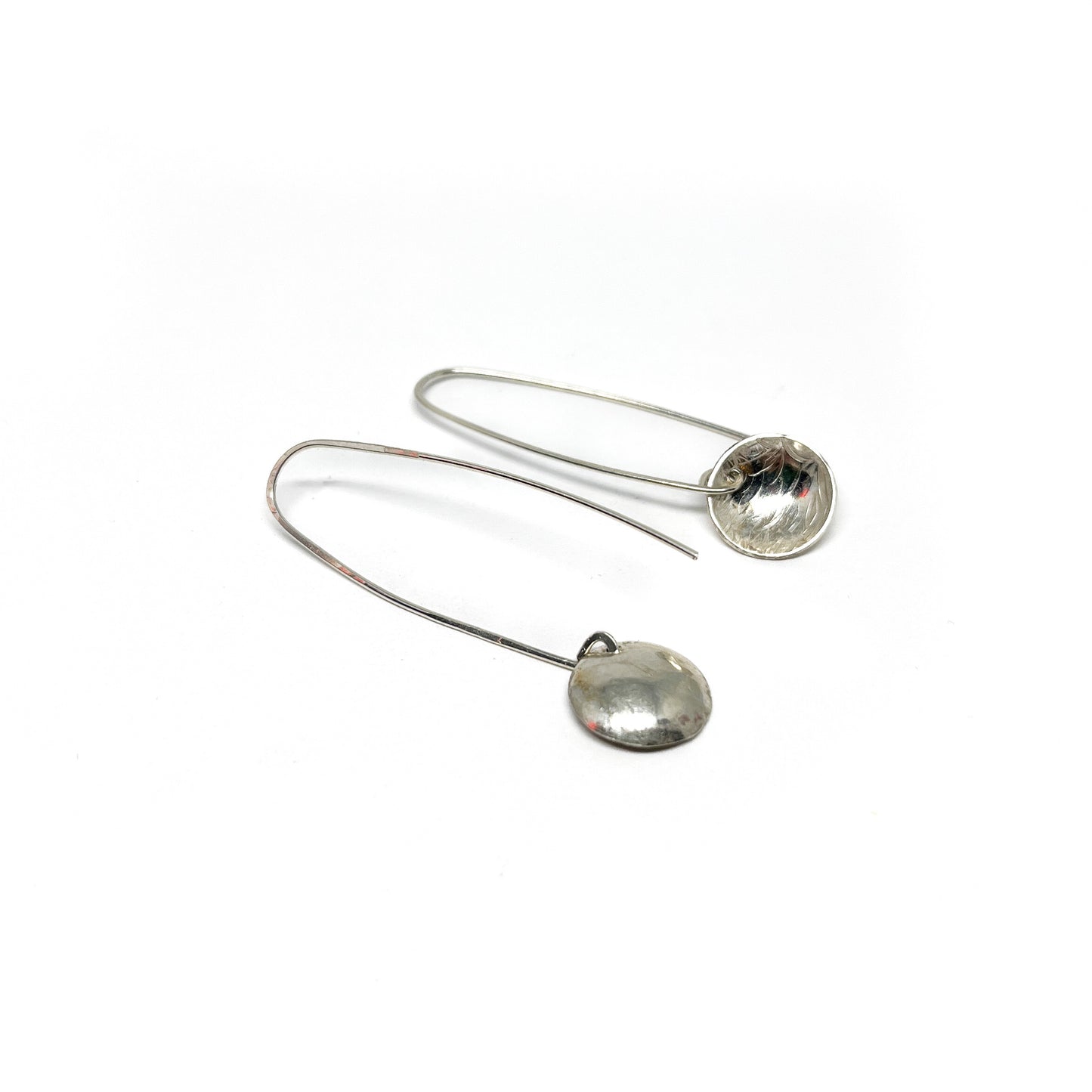 Reflective silver disk drop earrings with a curved post.
