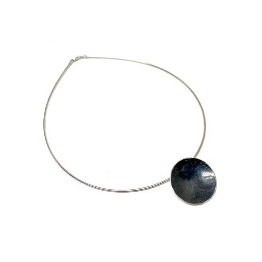 Silver Moonspace Pendant Necklace with a hammered, dark circular pendant.