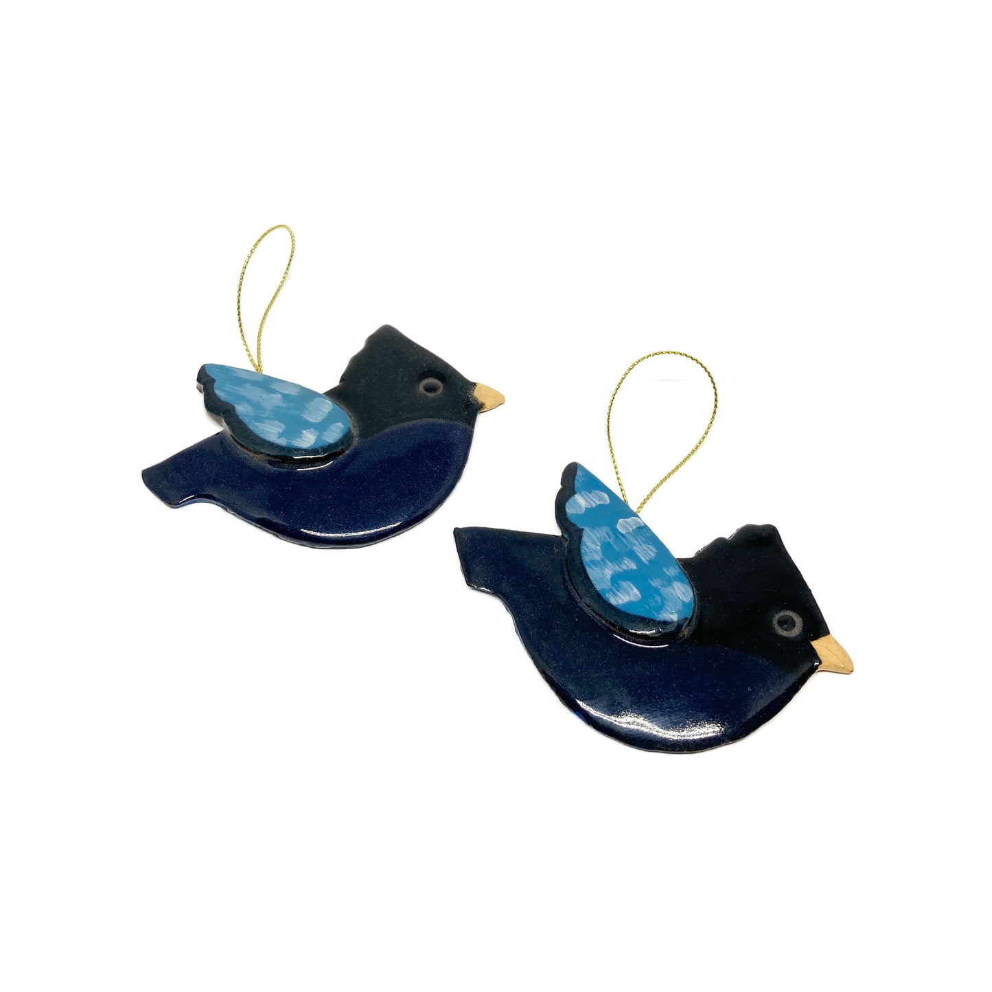 Two dark bird ornaments with light blue wings and gold strings.
