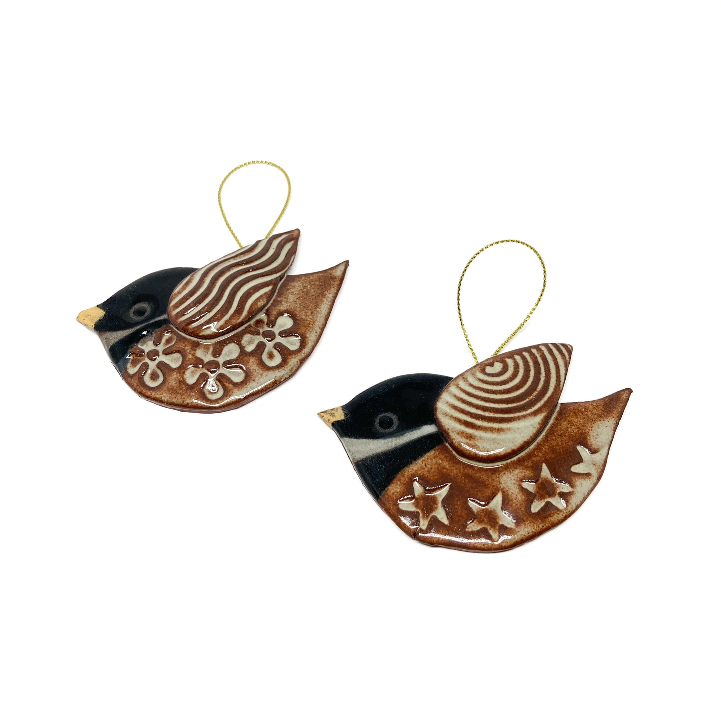 Two brown bird ornaments with floral and striped wing patterns and gold strings.