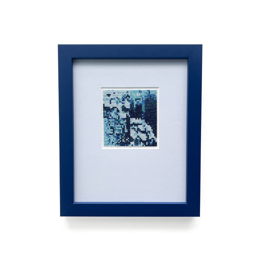 A framed cross-stitch titled "Blue Monochrome" featuring varying shades of blue.