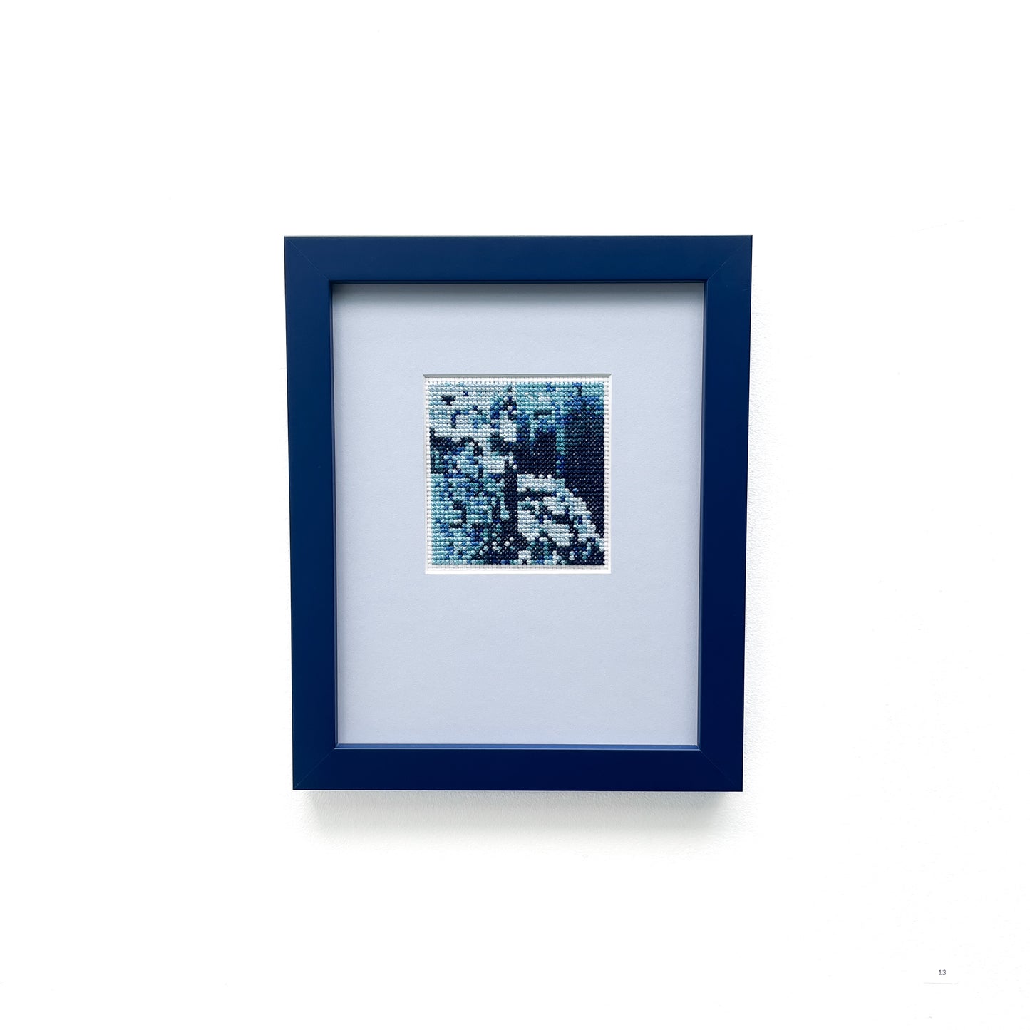 "Blue Monochrome" framed cross-stitch art, a piece featuring a design crafted in various shades of blue.
