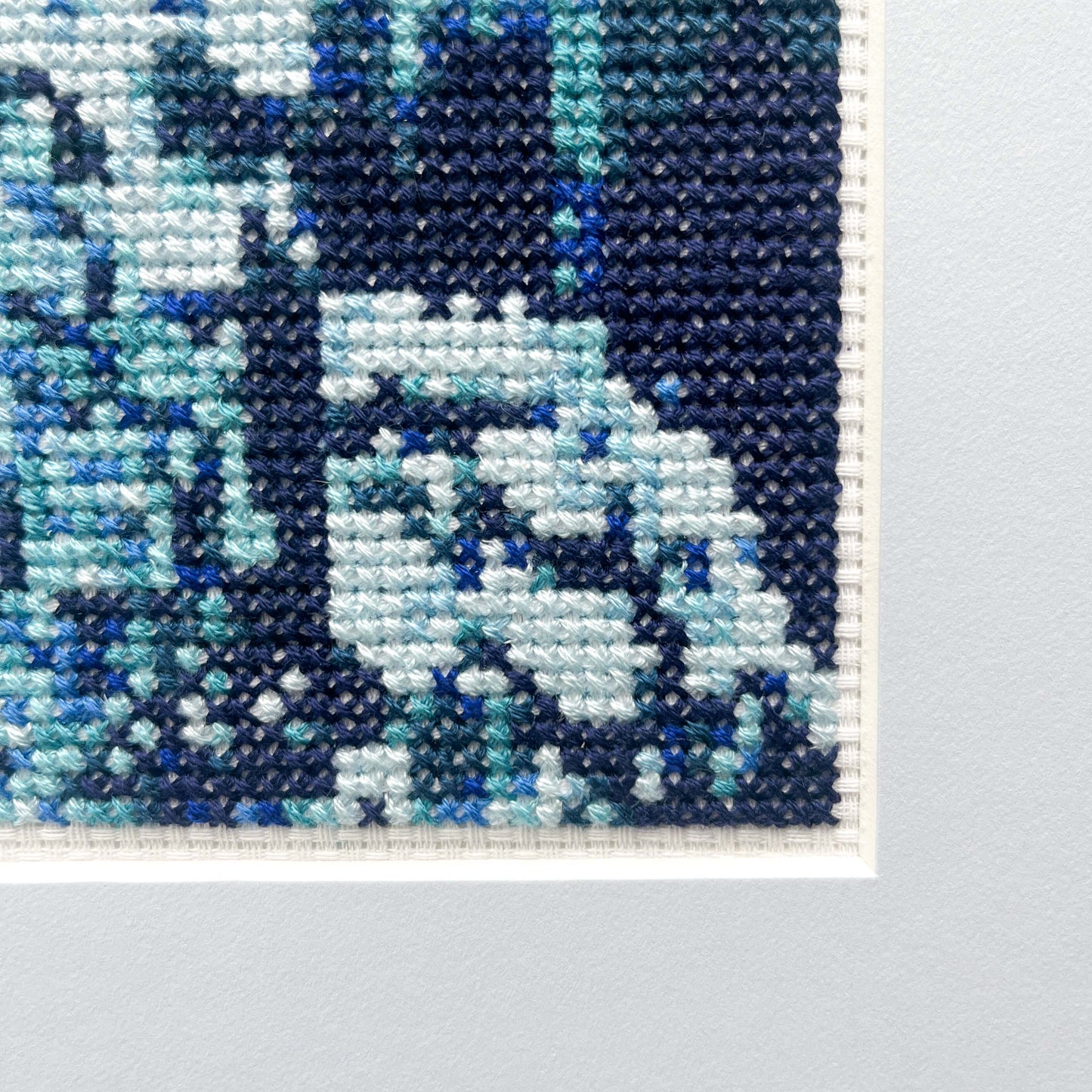 A detailed view of the "Blue Monochrome" cross-stitch, showcasing the texture and varying blue threads.