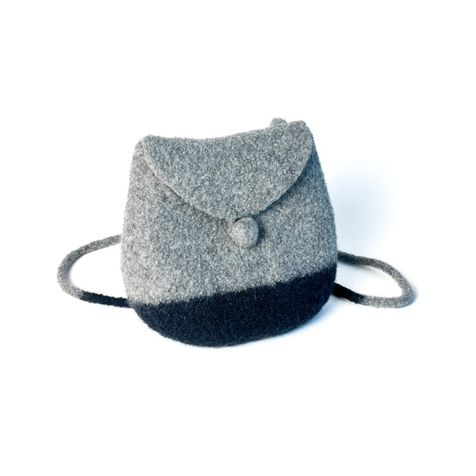 Two-tone felted backpack with a flap closure, button detail, and thin shoulder straps.
