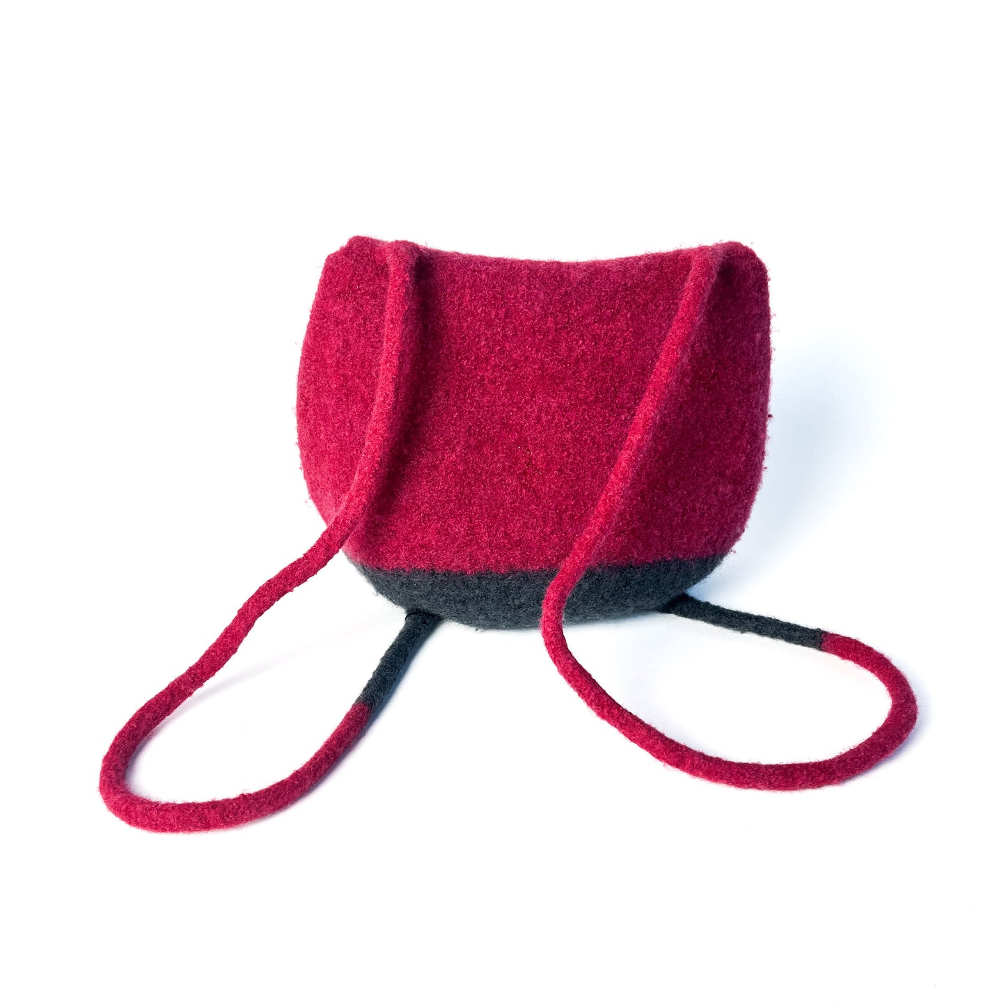 Two-tone felted backpack with a rounded shape and thin, looped shoulder straps. The back of the bag is visible, with the upper portion being a vibrant color.
