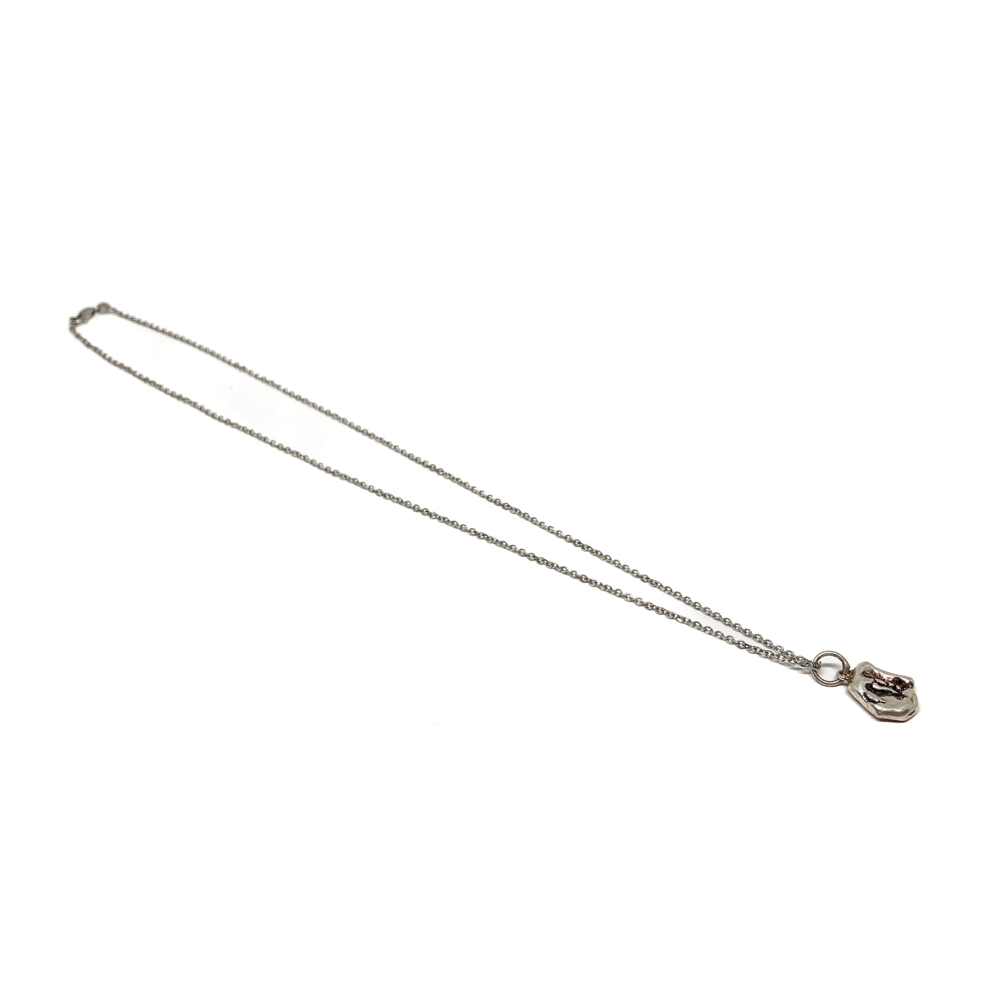 Small silver pendant on a delicate chain, angled view.