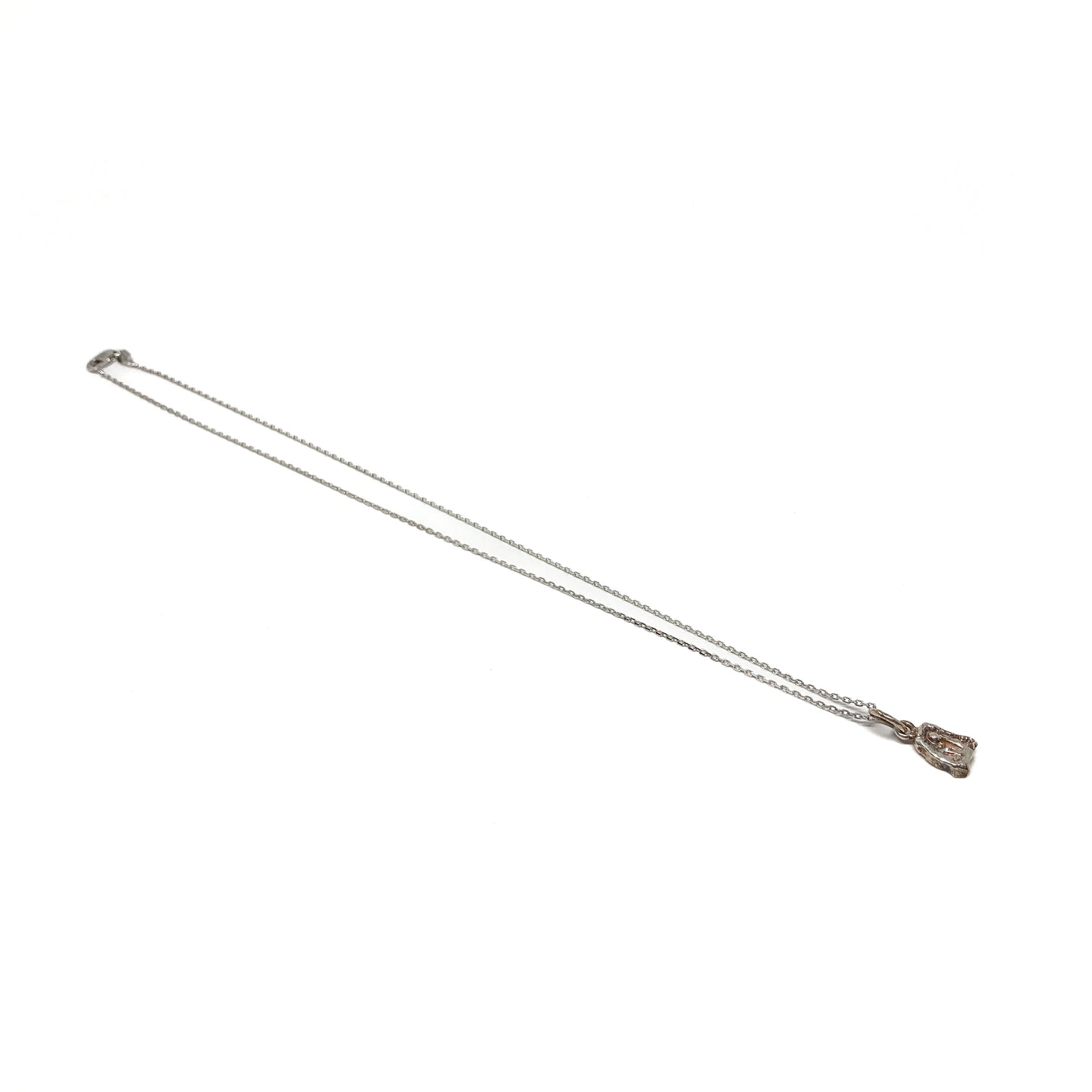 Small silver pendant necklace, lying diagonally.