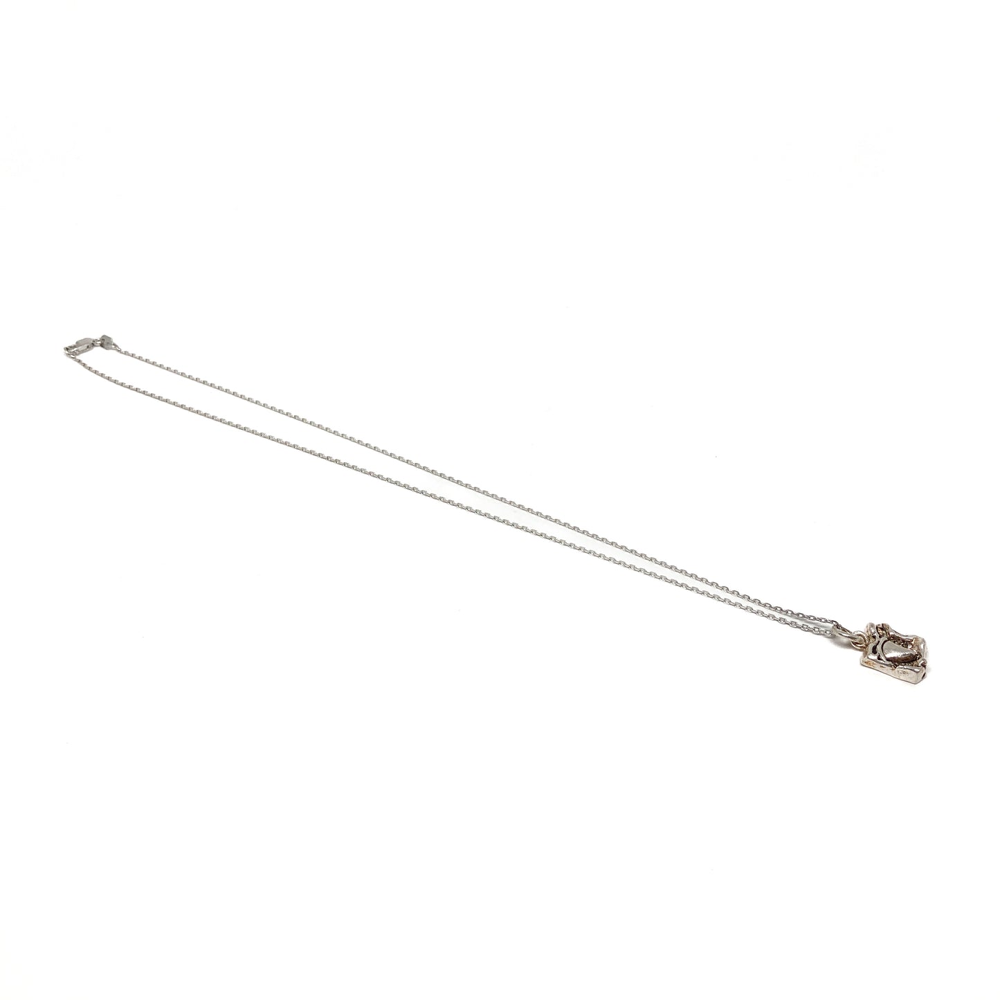 Small silver pendant necklace displayed at an angle.