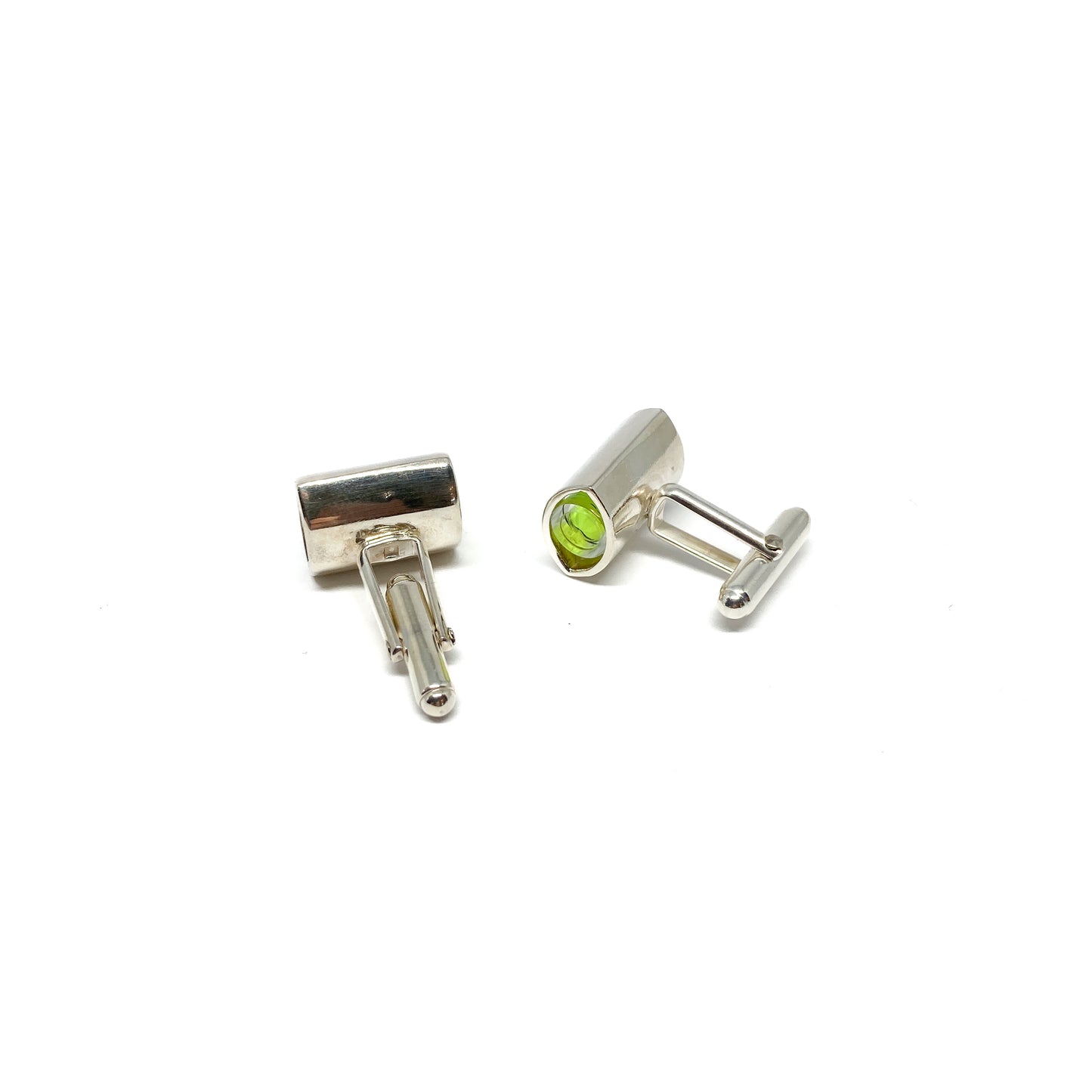 A pair of silver-toned cufflinks, each featuring a miniature spirit level with bright green liquid and an air bubble.