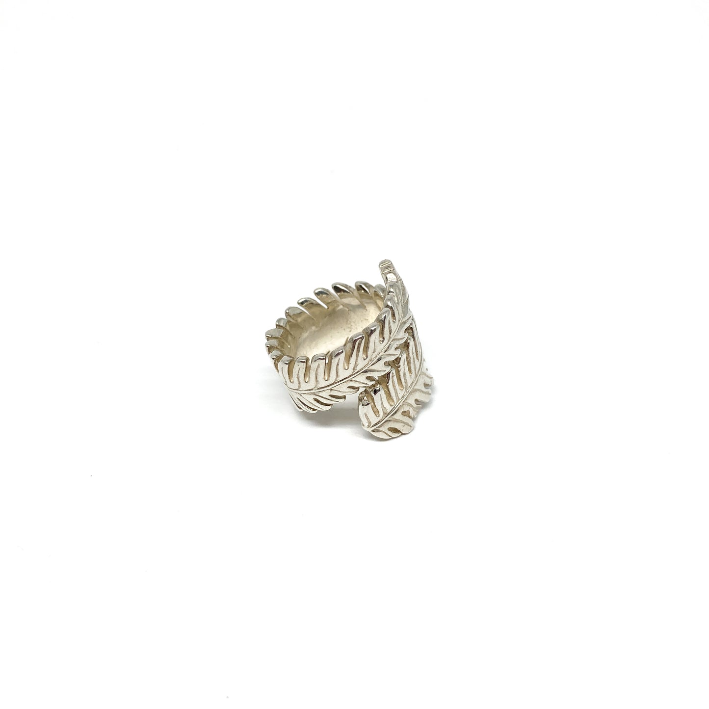 Silver ring shaped like a stylized fern leaf, wrapping around the finger.