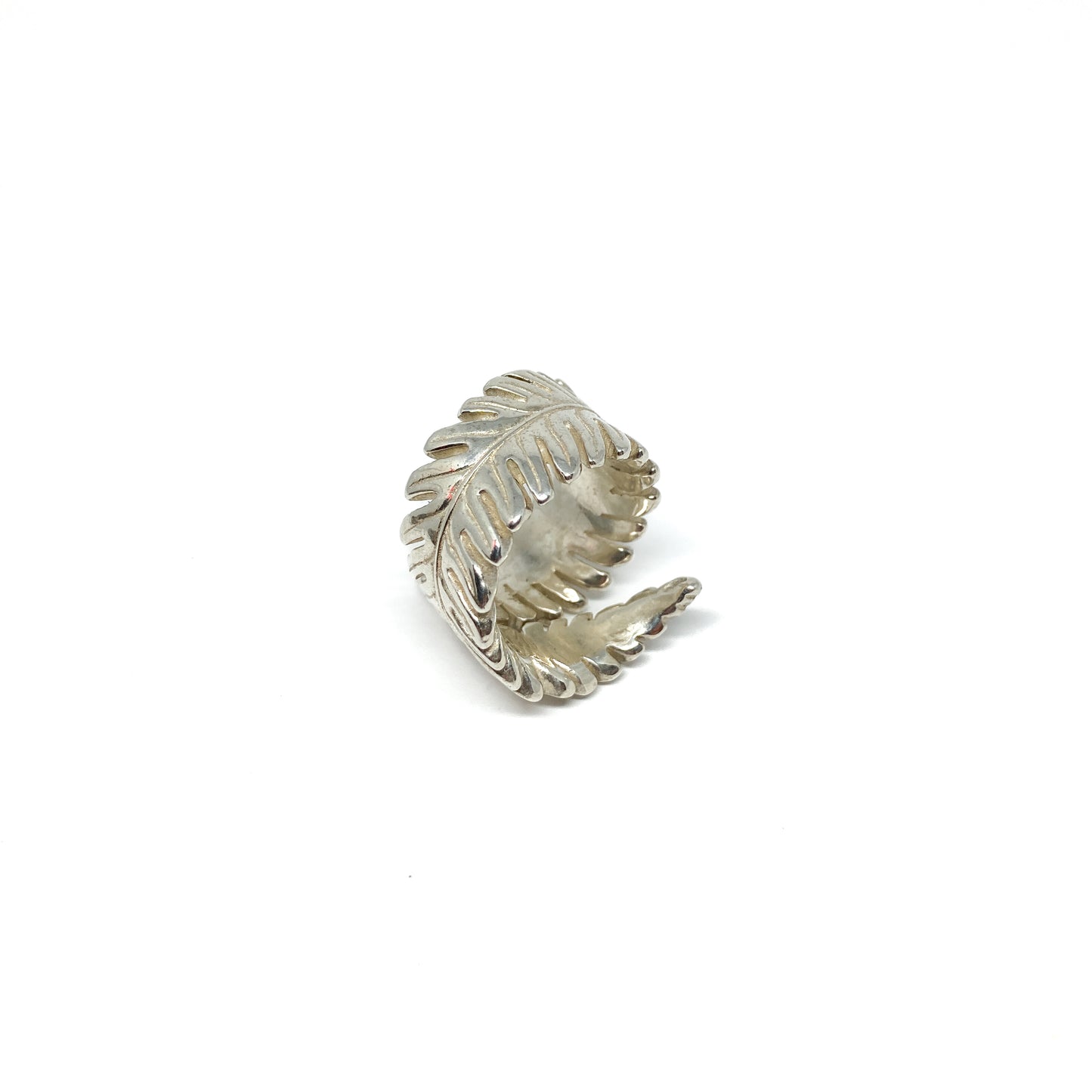 Silver ring shaped like a stylized fern leaf, wrapping around the finger.