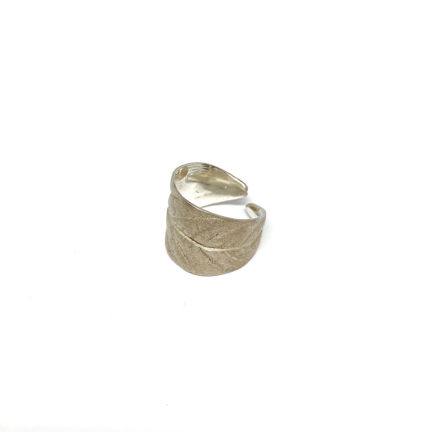 Silver ring with a textured, stylized leaf design that wraps around the finger.