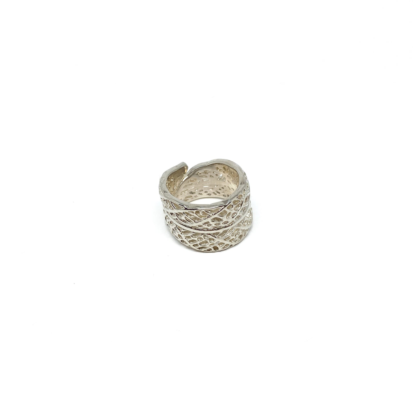 Silver ring with an intricate, openwork design resembling a lace leaf pattern.