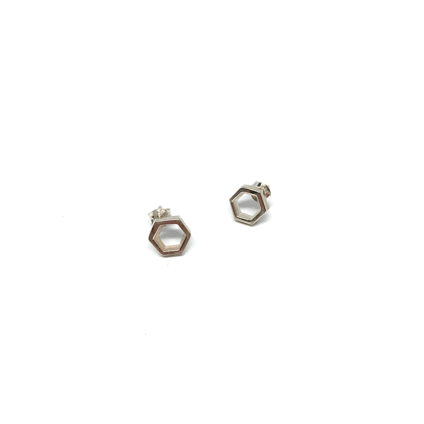 Two shiny silver stud earrings in the shape of open hexagons are displayed.