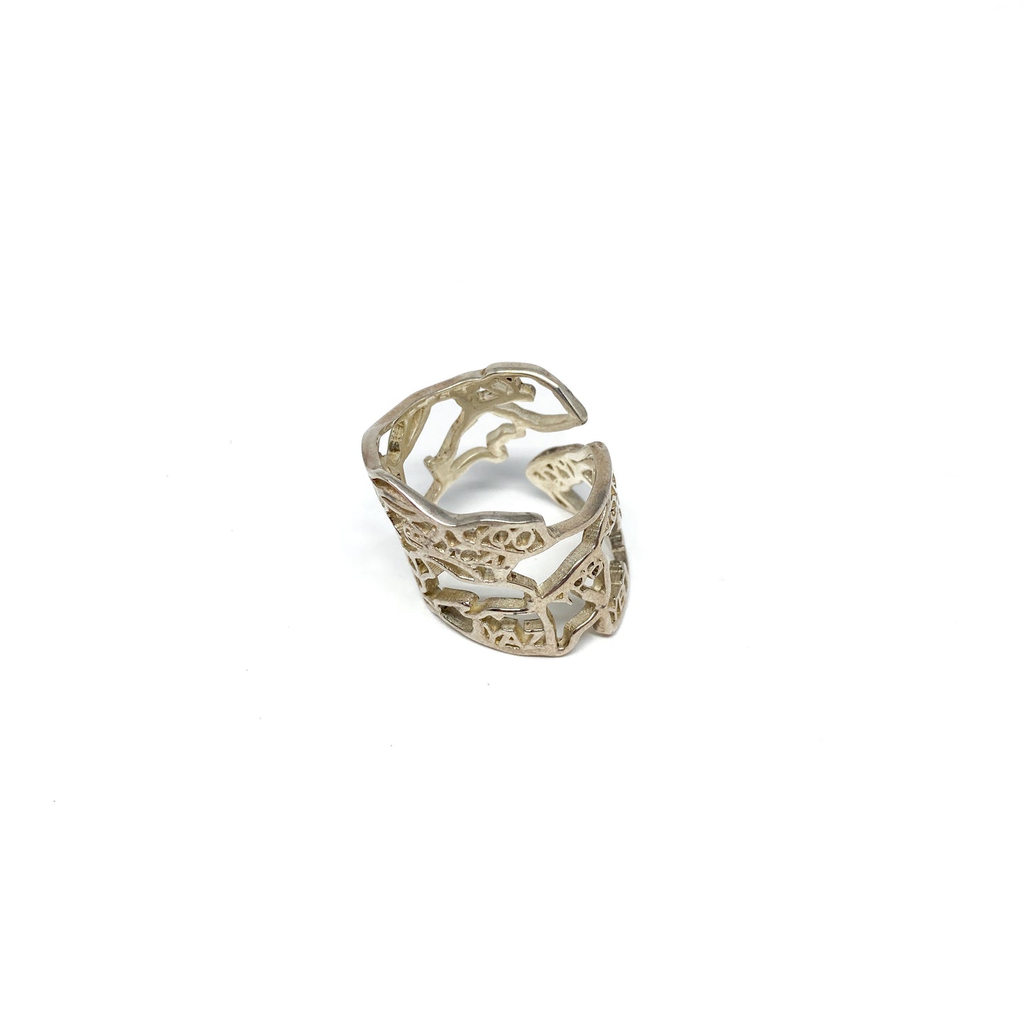 A shiny silver ring with an intricate cut-out design resembling the map of Canada is displayed.