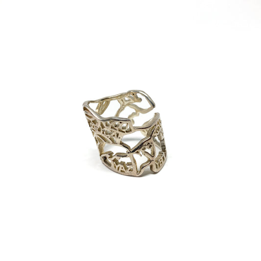 A shiny silver ring with a detailed cut-out design resembling a map of Canada is shown.