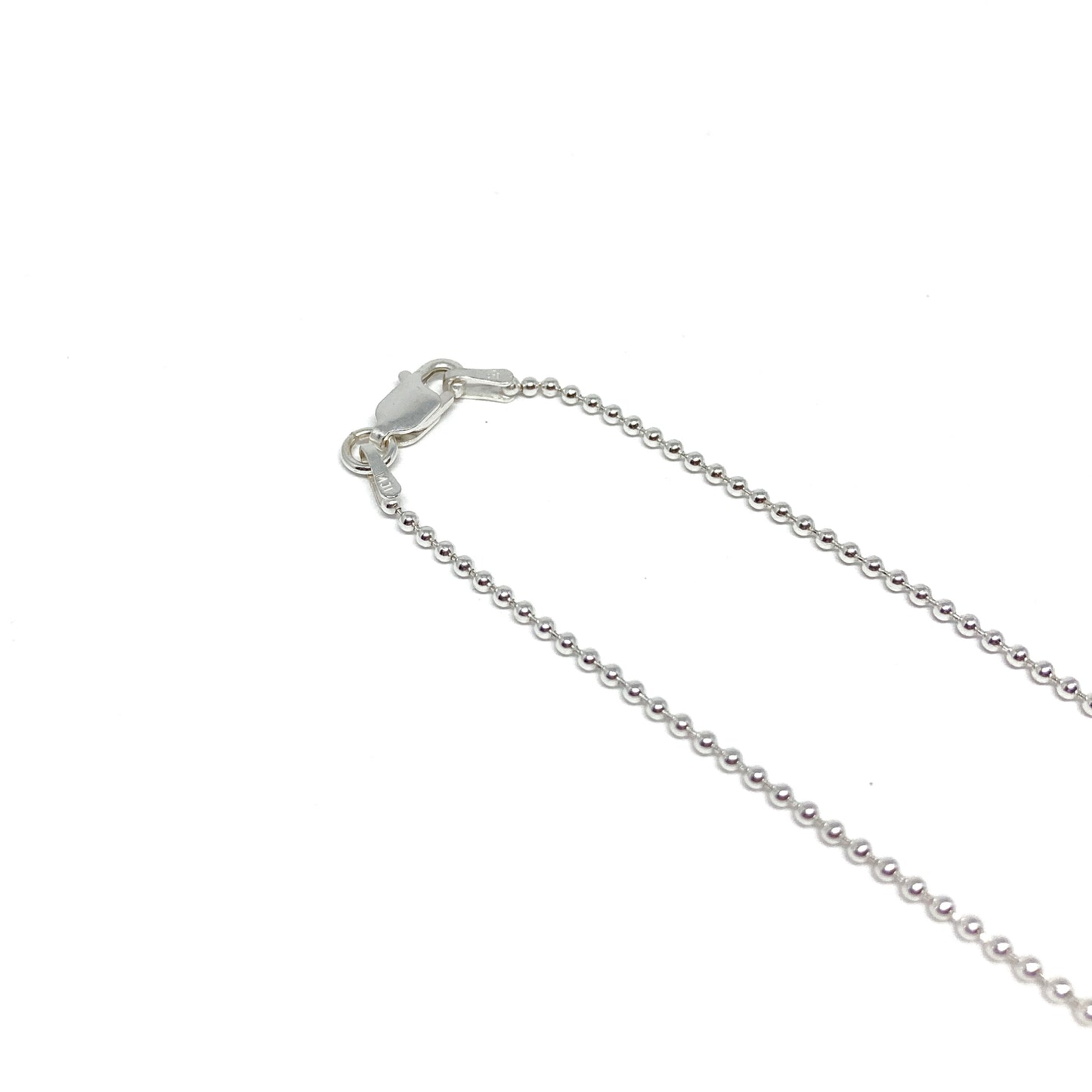 A close-up shows the lobster clasp and the small, spherical links of a silver ball chain.