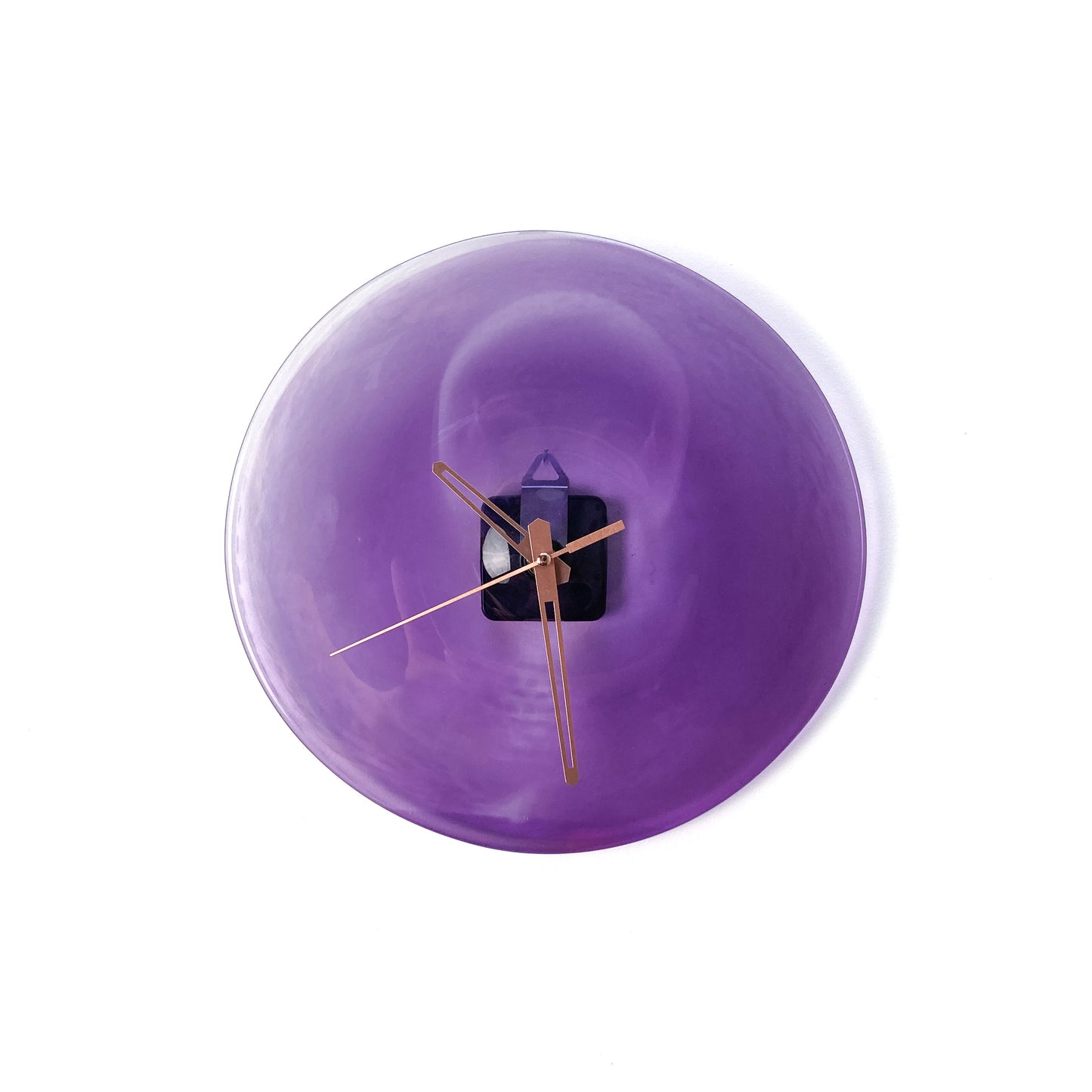 A round purple glass clock face with a lighter center, featuring thin gold-toned hour, minute, and second hands.
