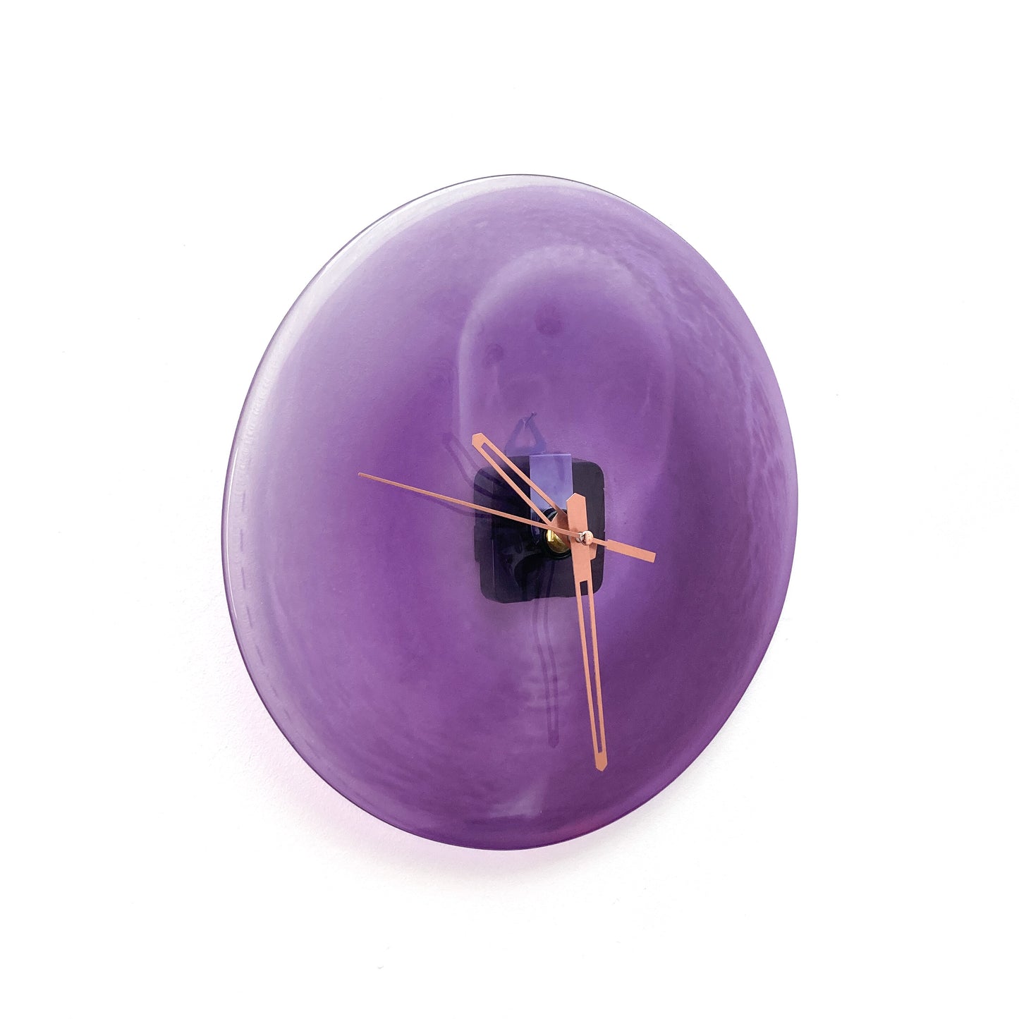 A round purple glass clock face with a lighter center, featuring thin gold-toned hour, minute, and second hands.