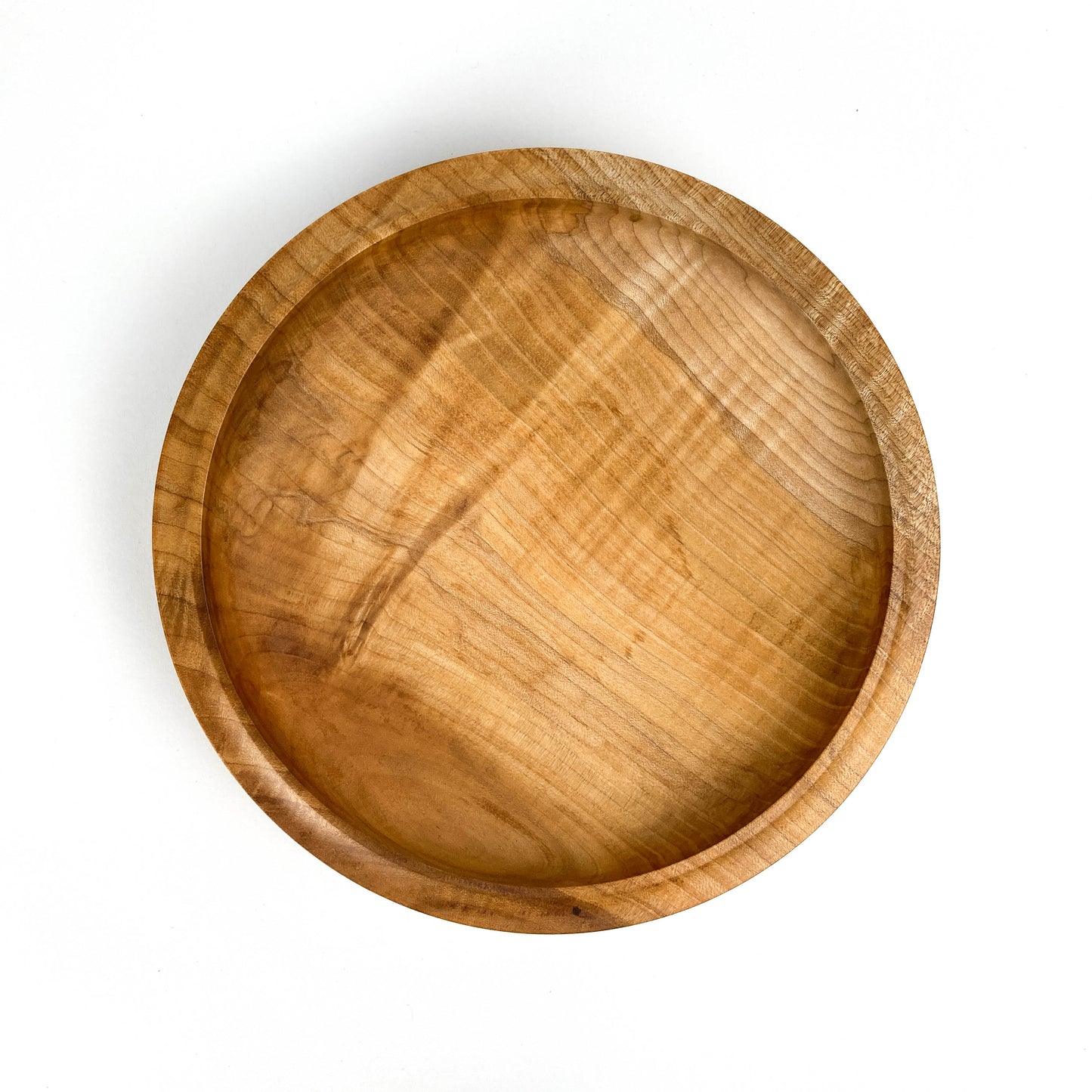 Top-down view of a circular maple bowl showcasing its natural wood patterns.