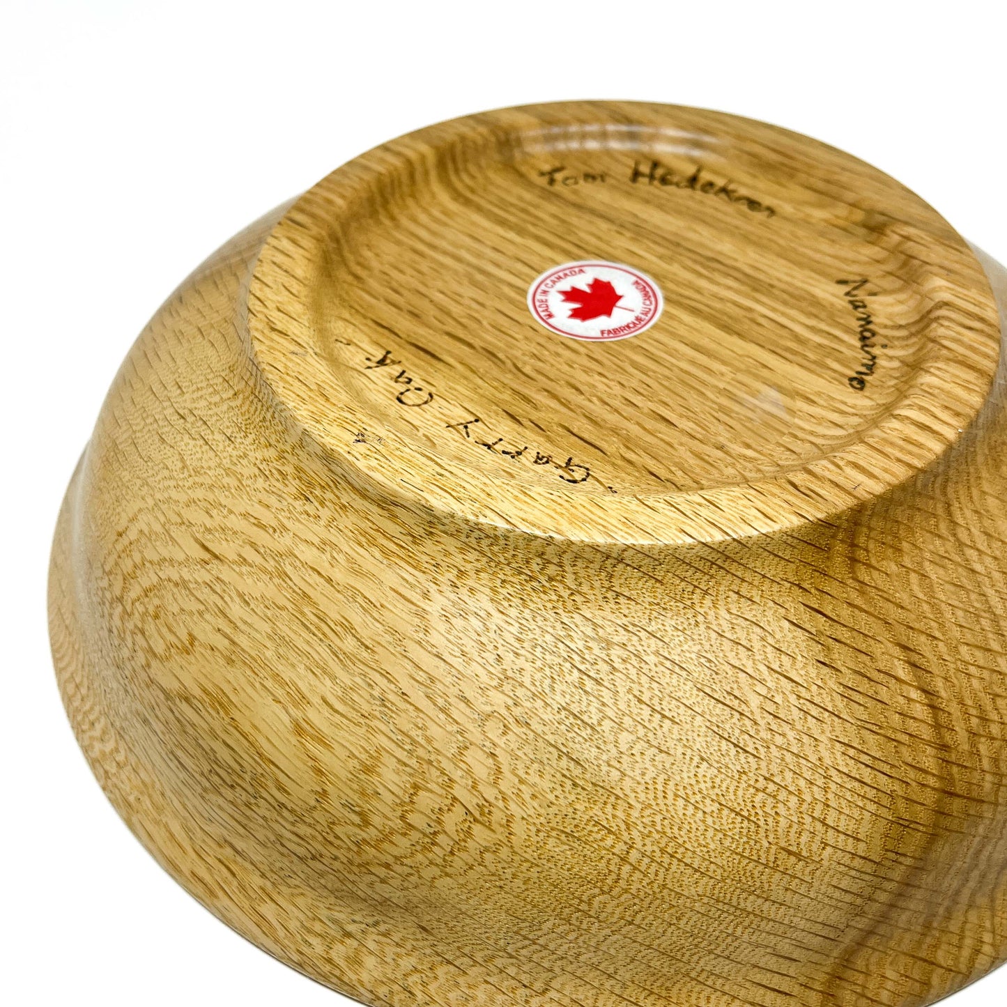 The underside of a Striped Garry Oak Bread Bowl, revealing engraved details and a "Made in Canada" sticker.