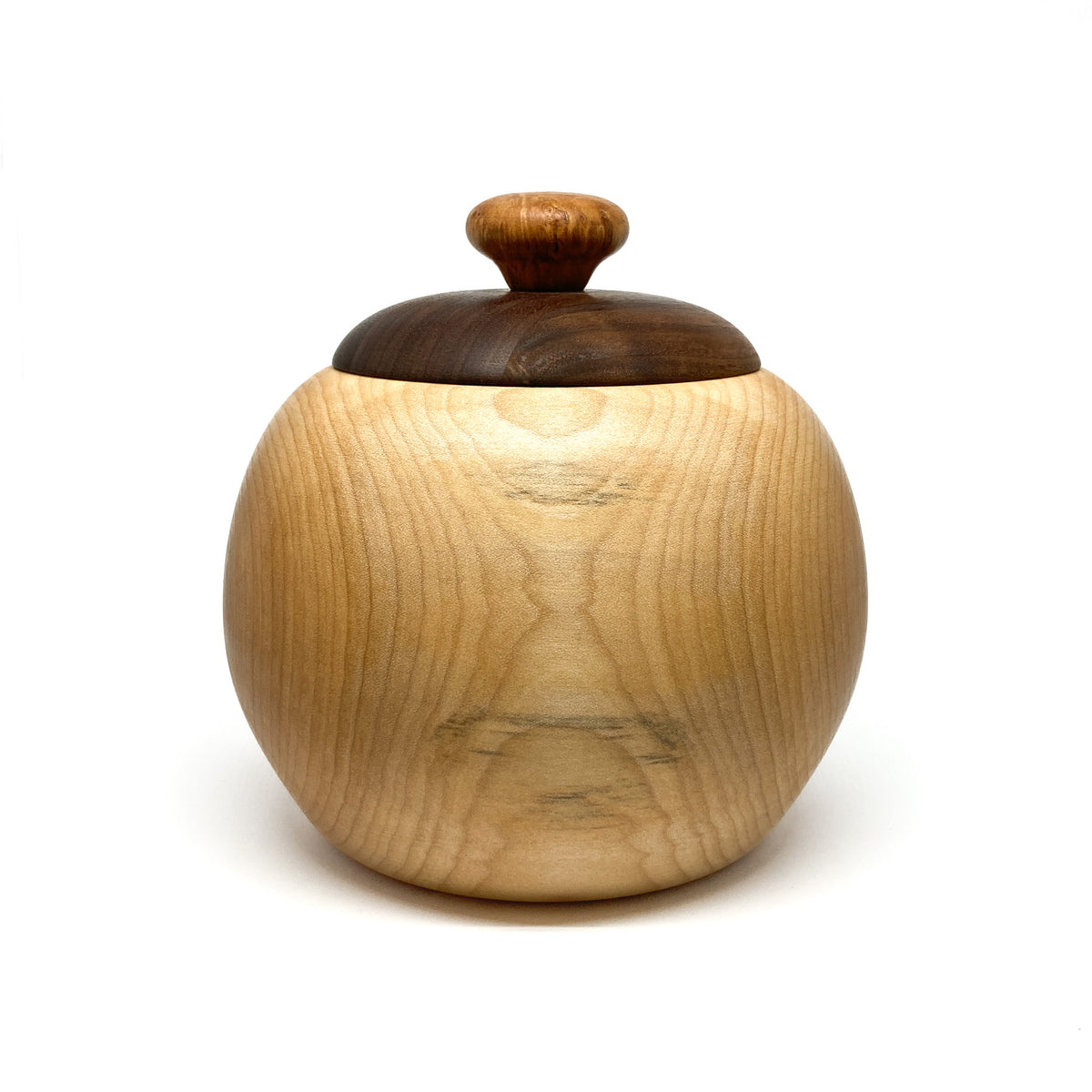 A lidded maple bowl with a dark walnut lid and a small, light-colored knob.